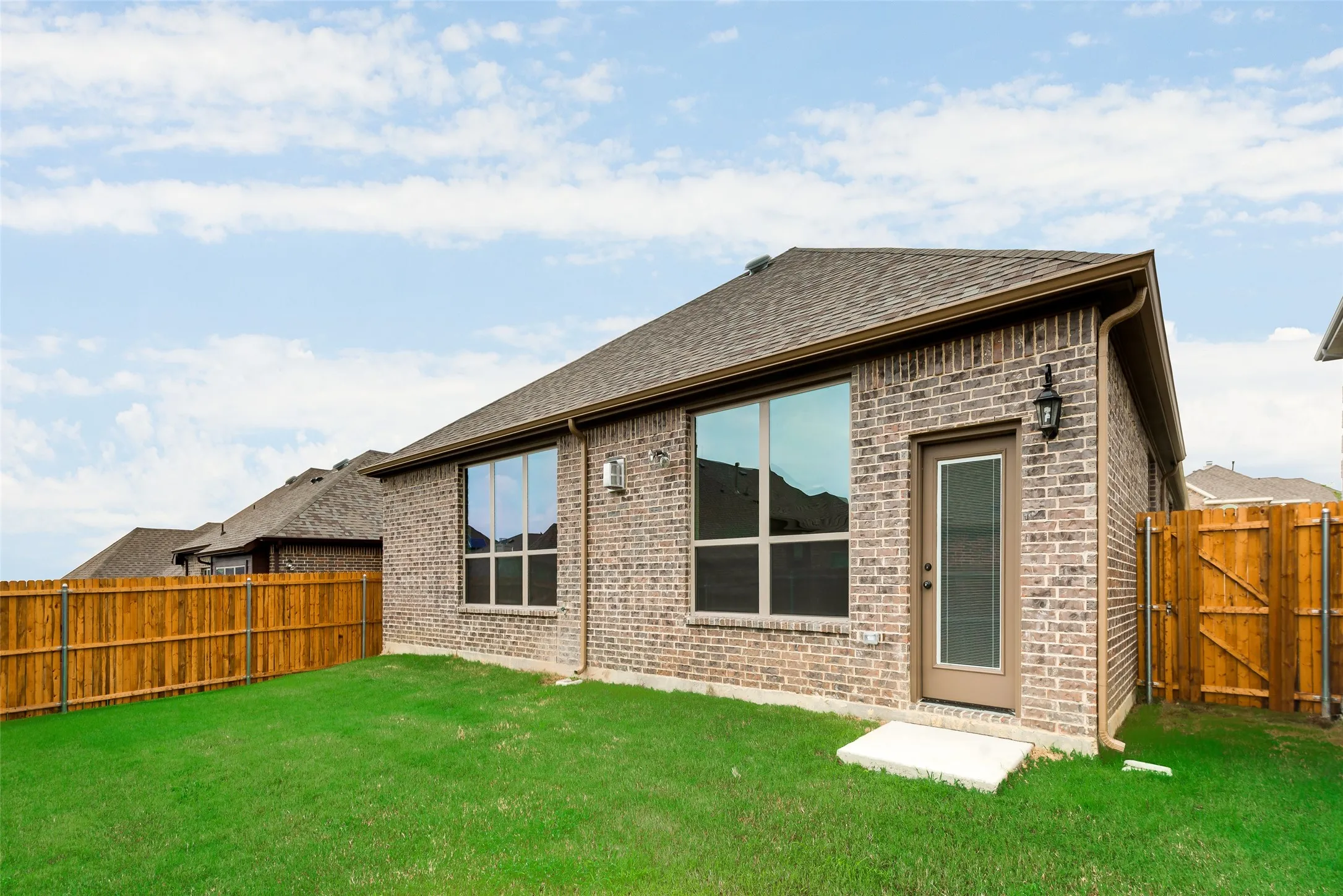 Brick exterior with a gabled roof and brown gutters