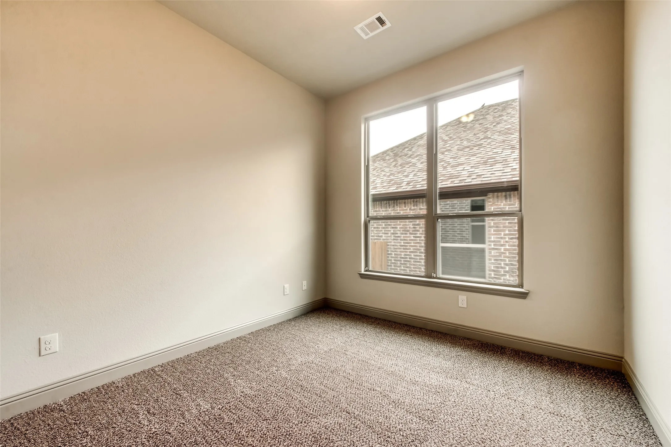 Neutral-toned walls, textured carpeting, large window, and recessed lighting
