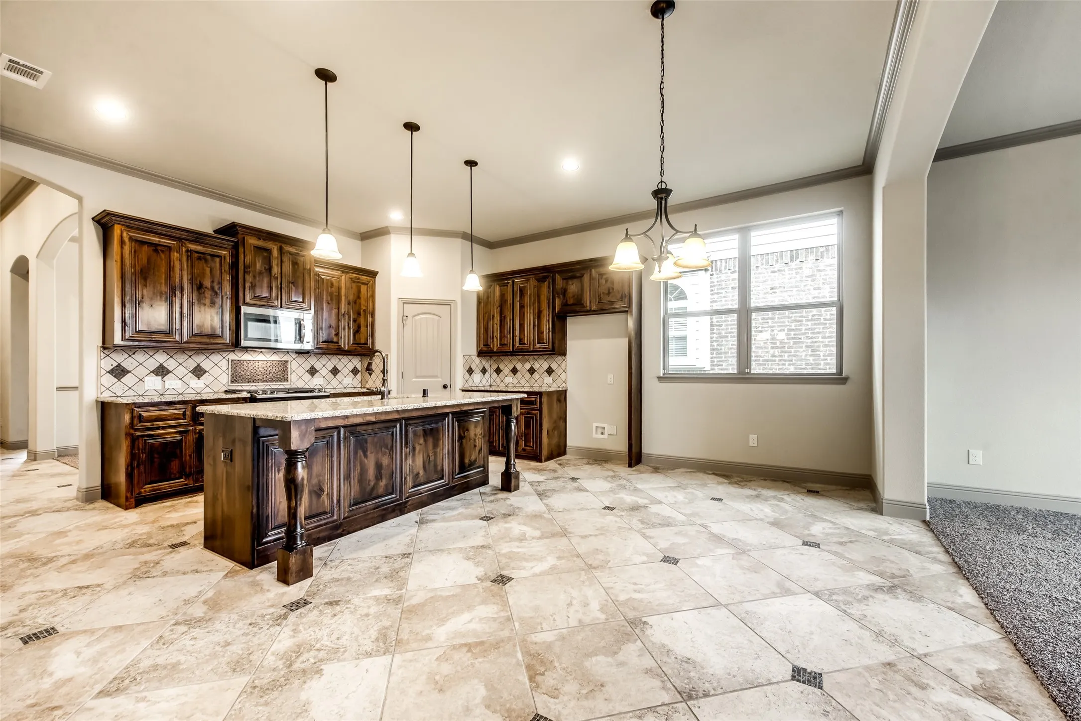 Kitchen featuring an island, recessed lighting, pendant lighting, wood-finish cabinetry, and tiled flooring with accent squares