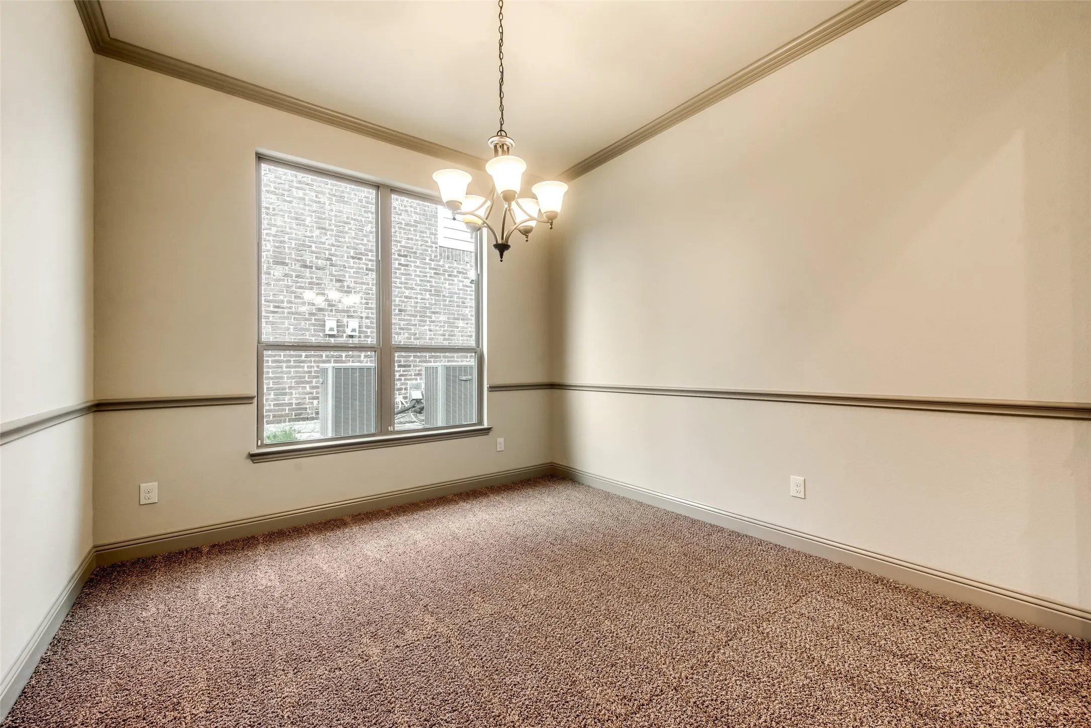 Recessed ceiling with a bronze-finish chandelier, crown molding, chair rail, and wall-to-wall carpeting