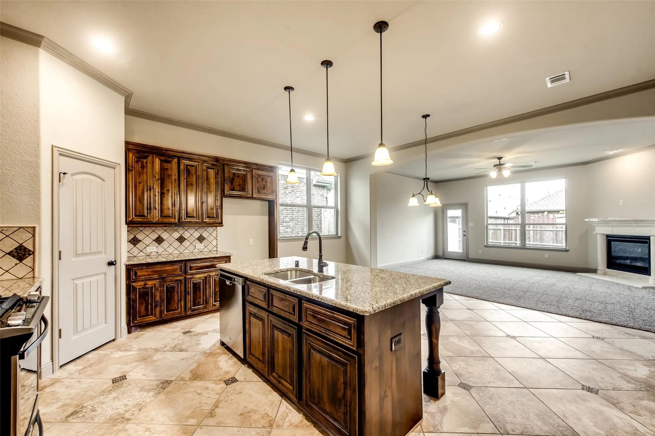 Kitchen featuring wood cabinetry, stone countertops, stainless steel appliances, and tile flooring