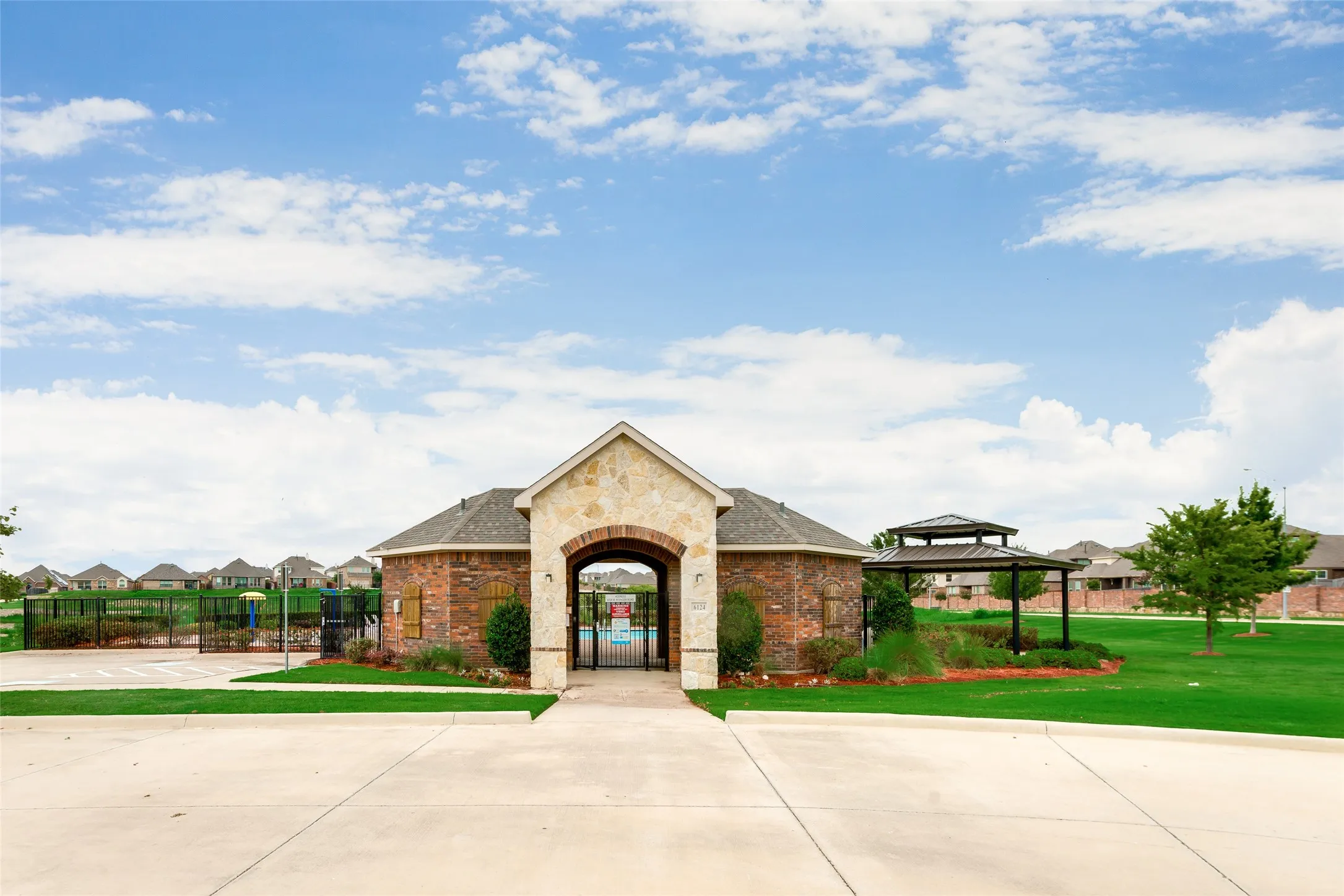 Stone and brick facade clubhouse with an arched entryway