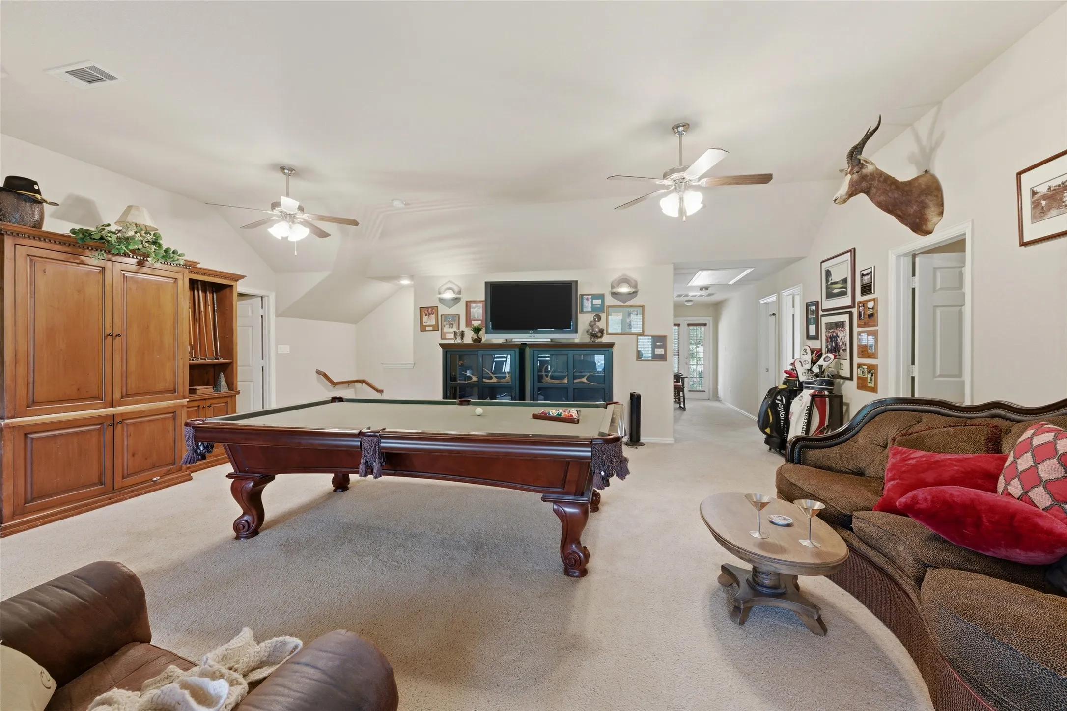 Spacious bonus room featuring vaulted ceilings and multiple ceiling fans