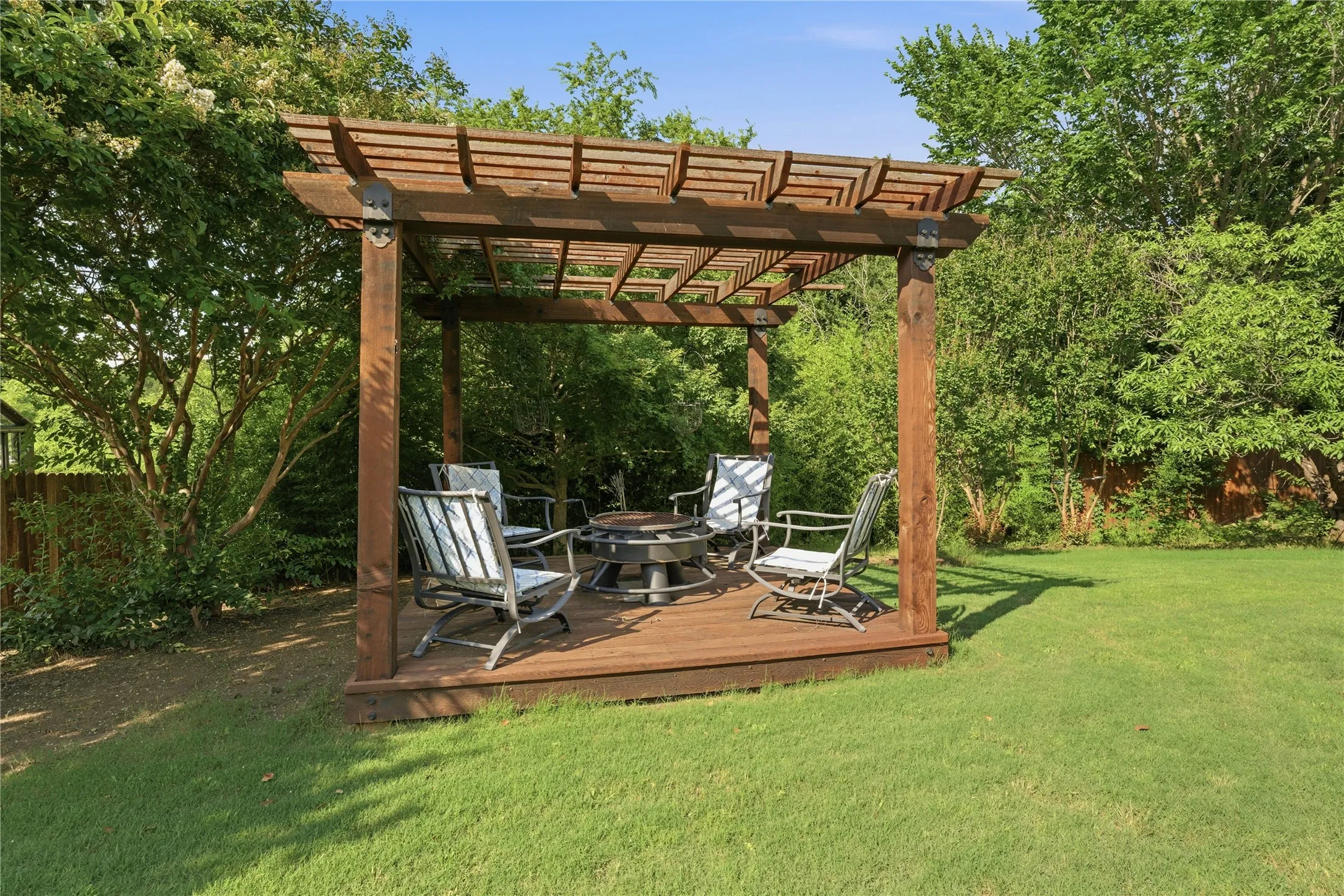 Expansive lawn featuring a wooden pergola with a built-in deck