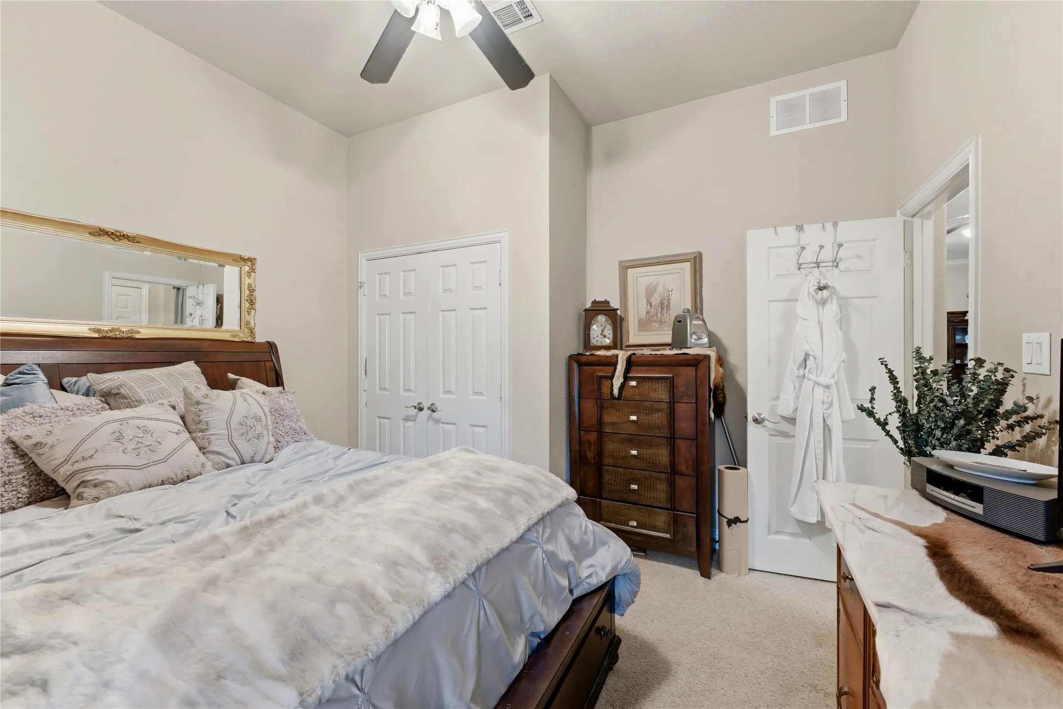 Vaulted ceiling with ceiling fan, carpeted flooring, and white paneled closet doors