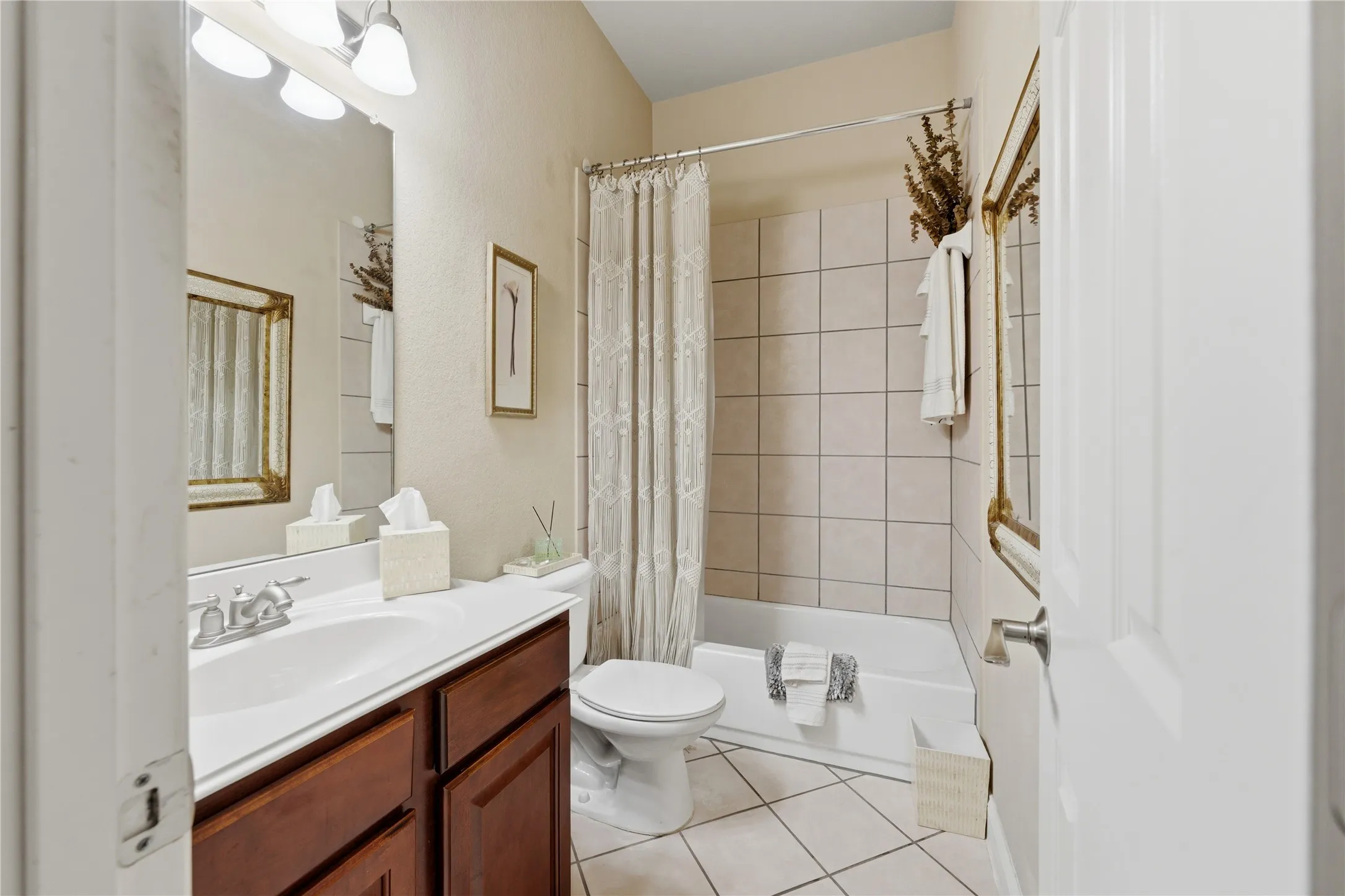 Bathroom featuring a single vanity with wood-finish cabinetry, a white countertop, and an integrated sink