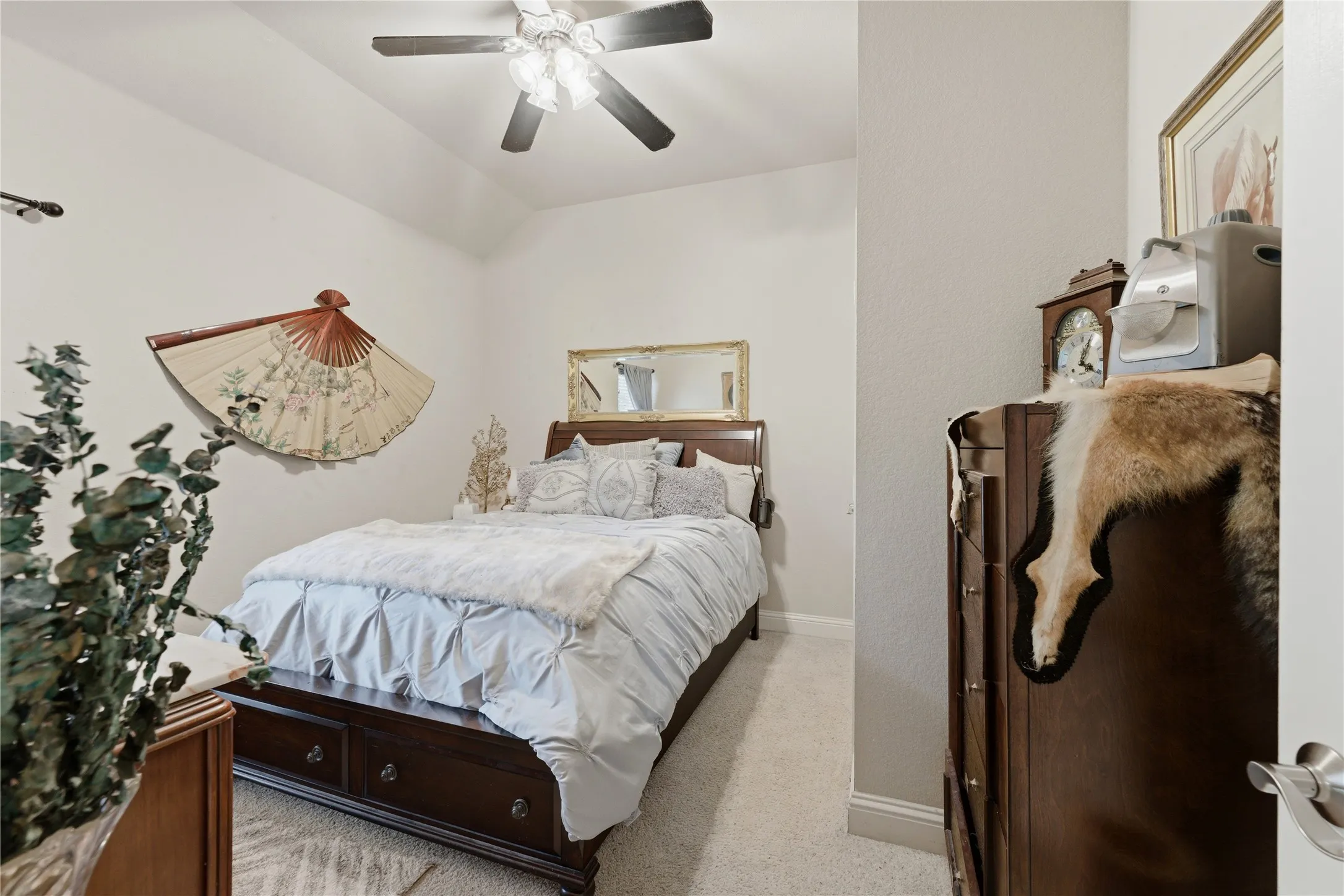 Carpeted flooring, vaulted ceiling, and a ceiling fan with integrated lighting