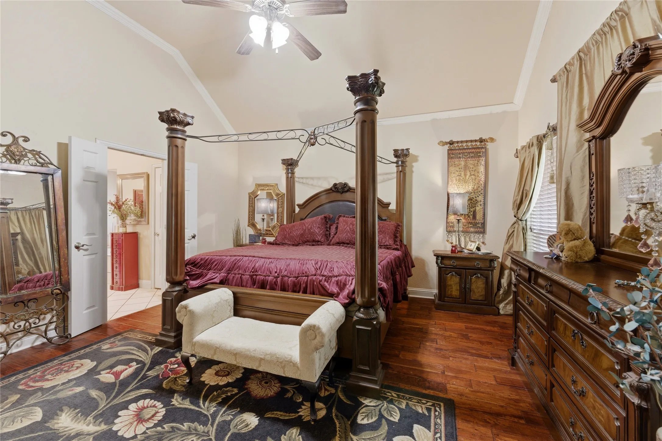 Vaulted ceiling, wood-finish flooring, ceiling fan, and double panel doors