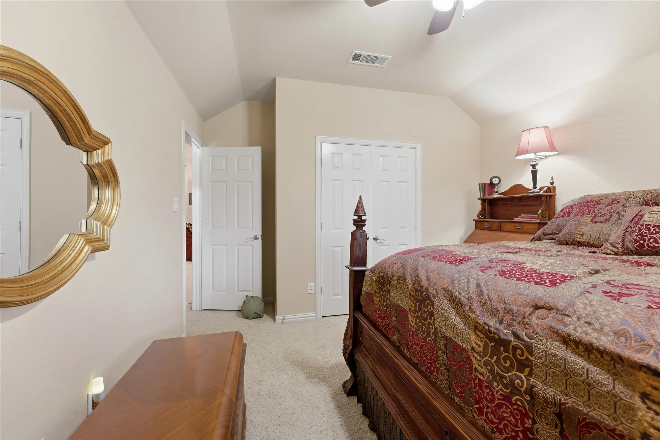 Vaulted ceiling with a ceiling fan, carpet flooring, and paneled doors