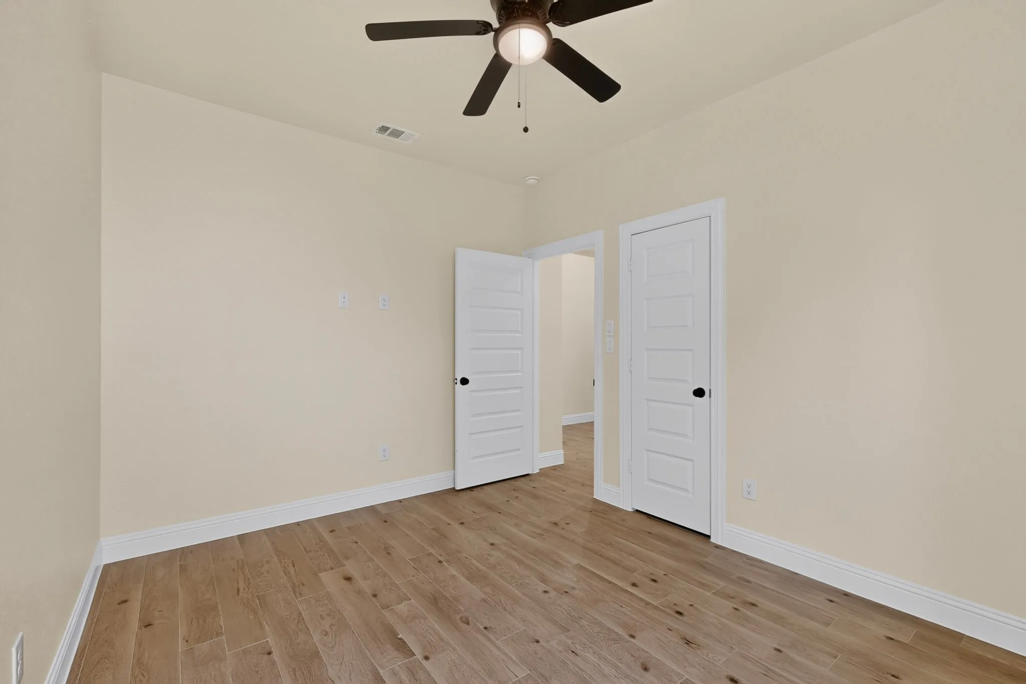 Wood-finish flooring throughout, paired with light-toned walls and white trim