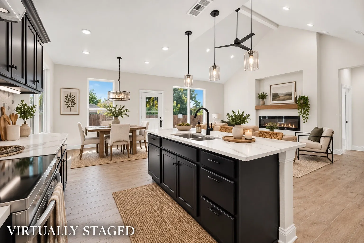 Kitchen island with undermount sink and matte black faucet, wood-finish flooring, vaulted ceilings, recessed lighting, and a linear fireplace with wood mantel