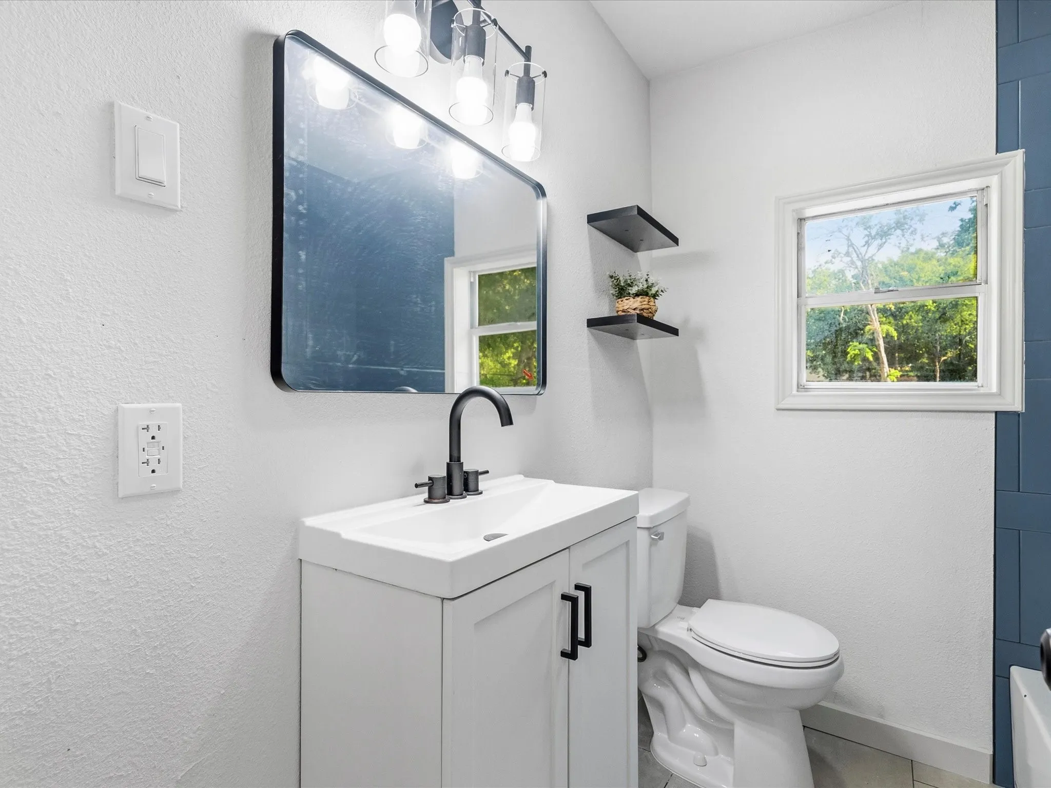 Modern vanity with black hardware and faucet
