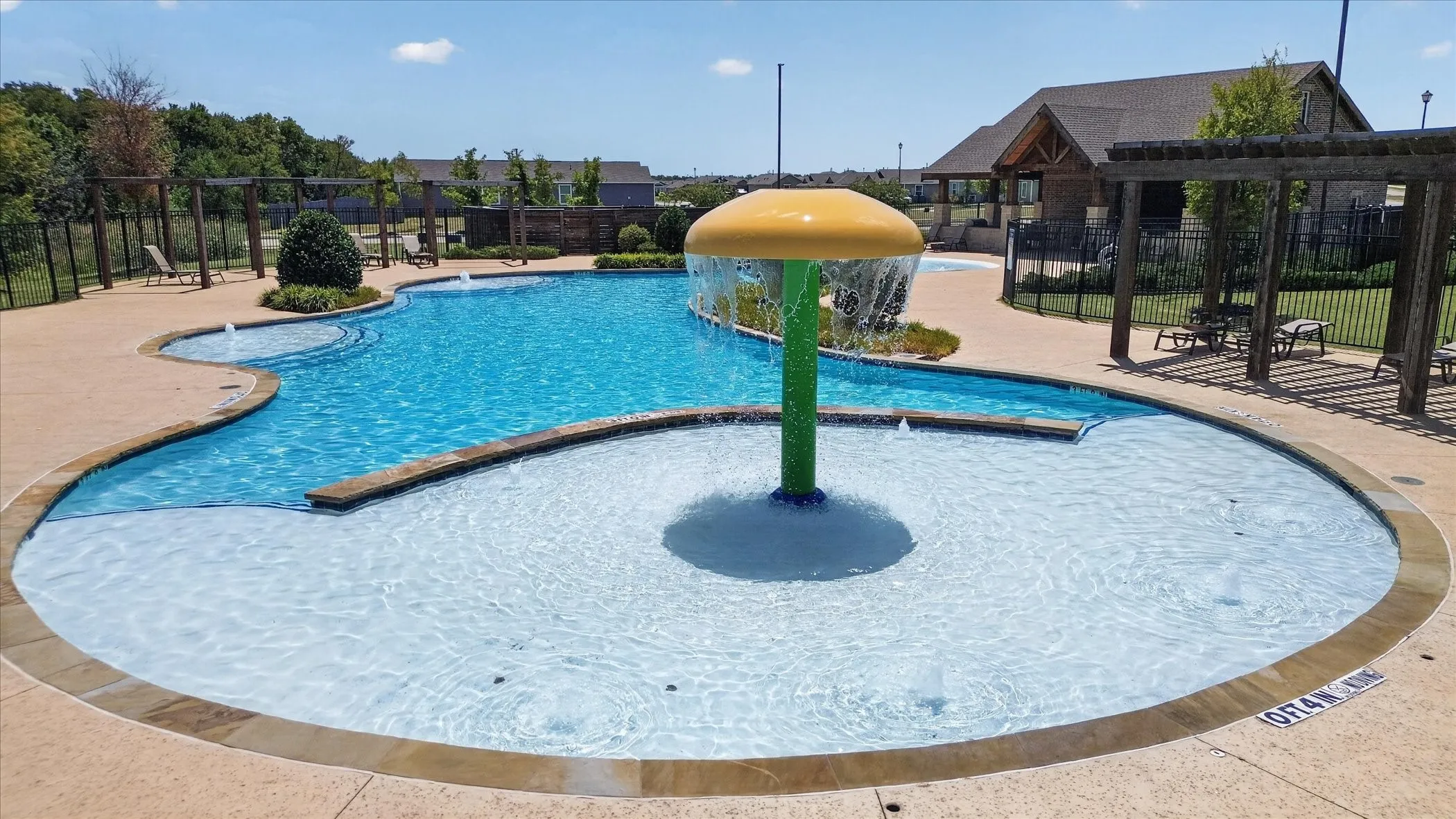 Expansive multi-pool aquatic area featuring a zero-entry section, water feature, and integrated spa