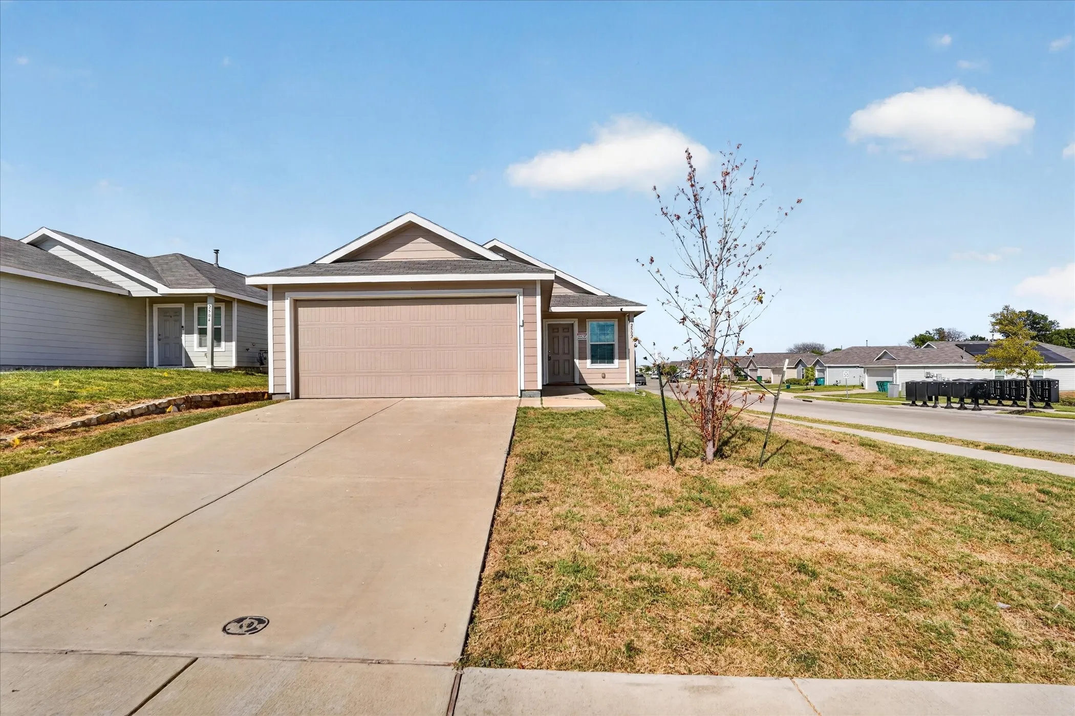 Single-story residence featuring a two-car garage, concrete driveway, and a front facade with neutral siding