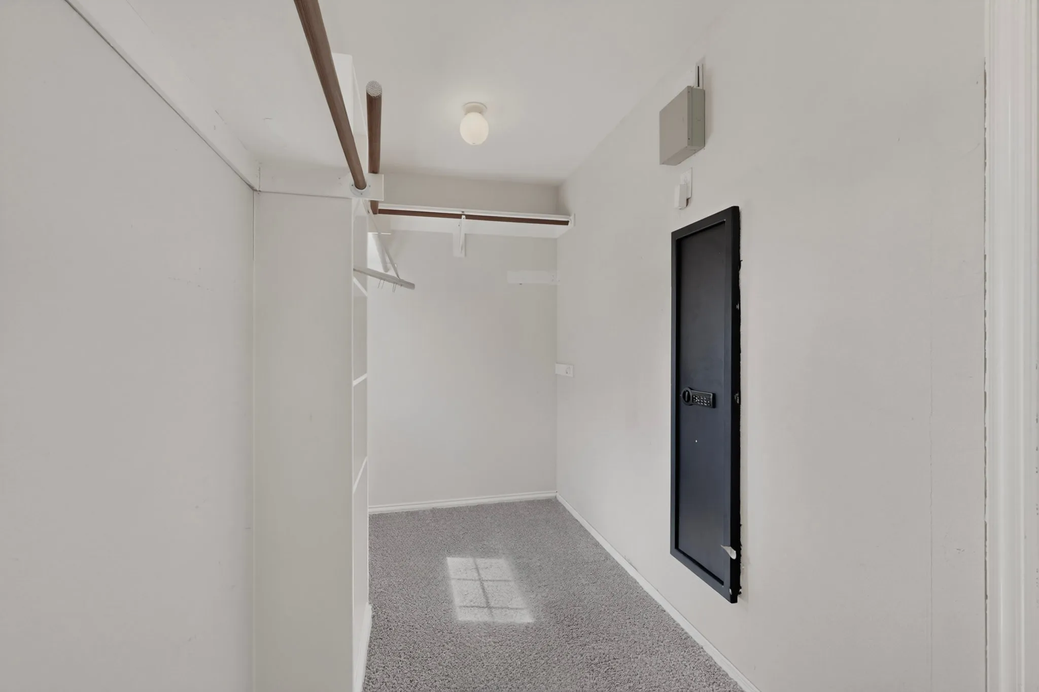 Recessed shelving, built-in clothing rod, overhead lighting, and wall-mounted safe