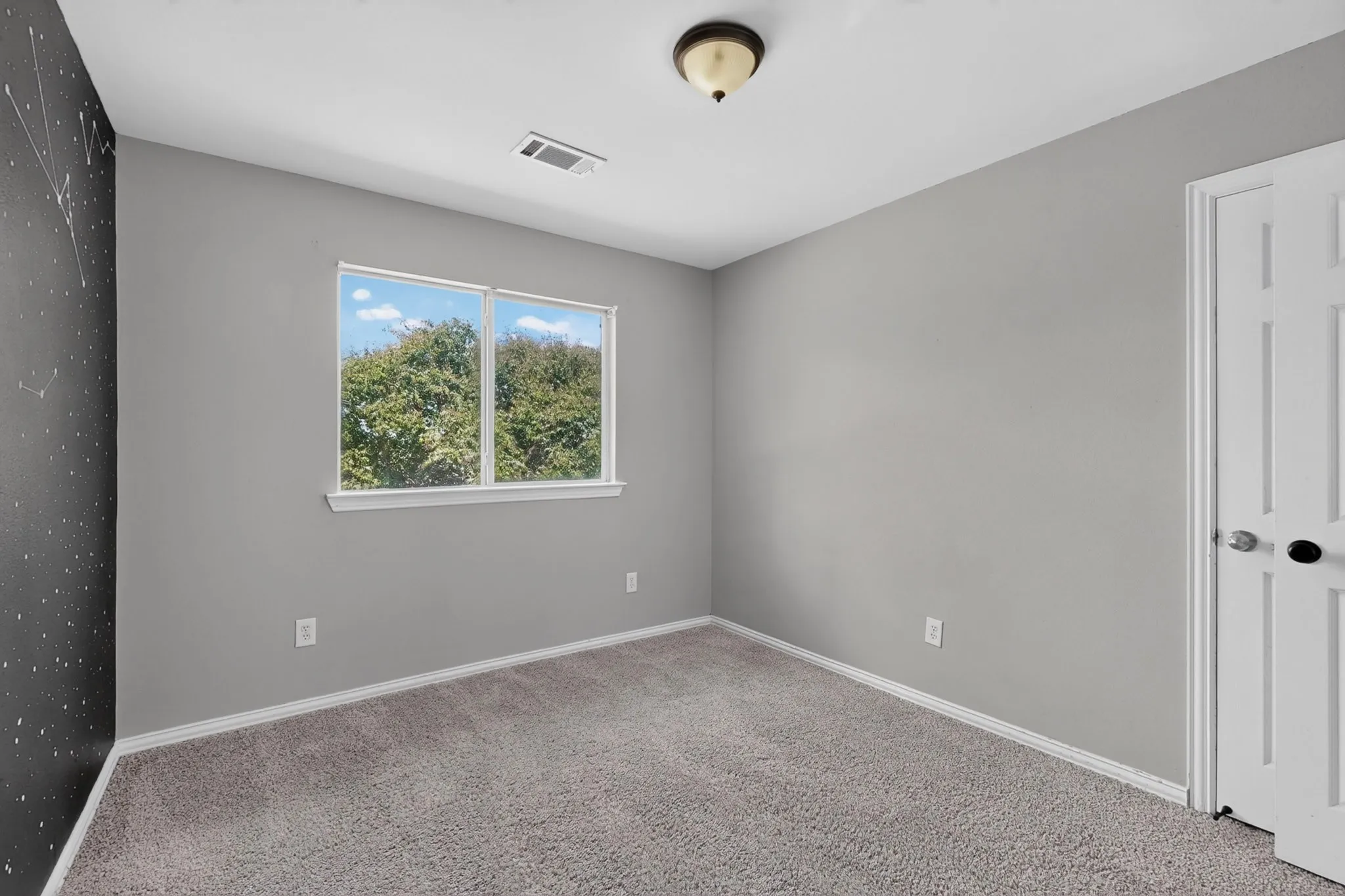 Soft gray wall finishes and a contrasting accent wall with a celestial motif