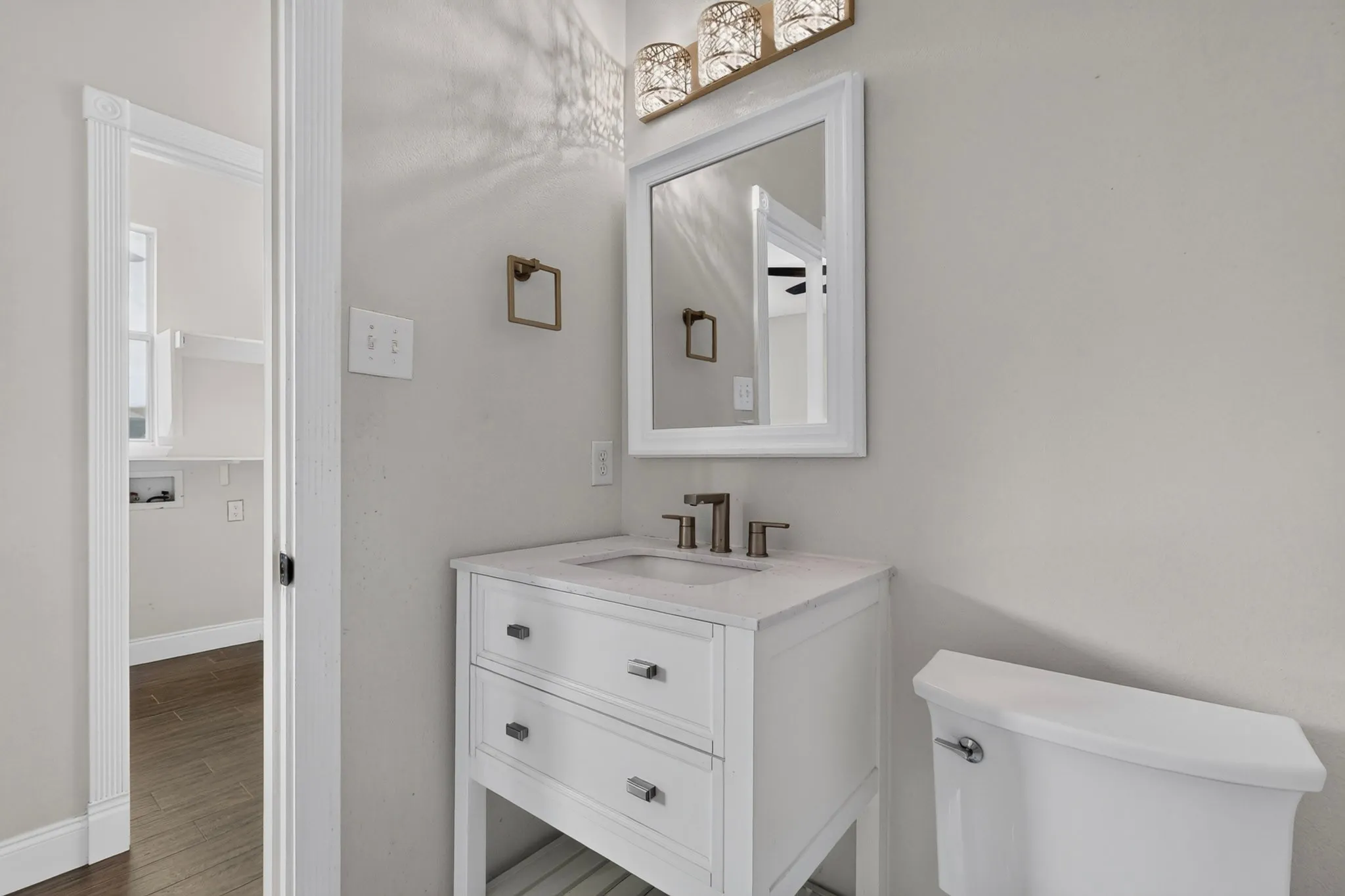 White vanity with two storage drawers, integrated sink, and brushed nickel fixtures