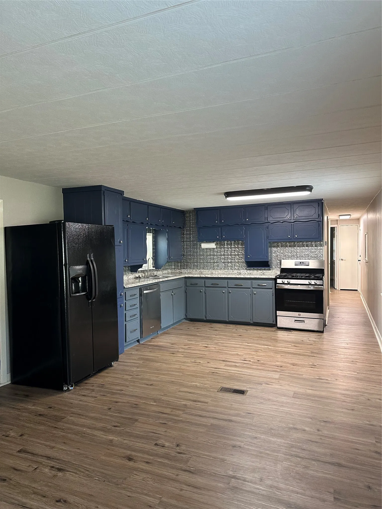 Kitchen with refrigerator (water and ice through the door); Stainless Steel KitchenAid D/W; modern gas range.