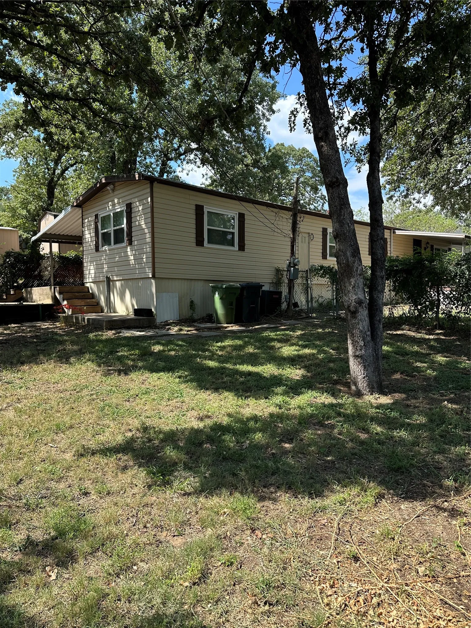 View of front facade featuring concrete walkways around perimeter with grassy, shaded lawn.
