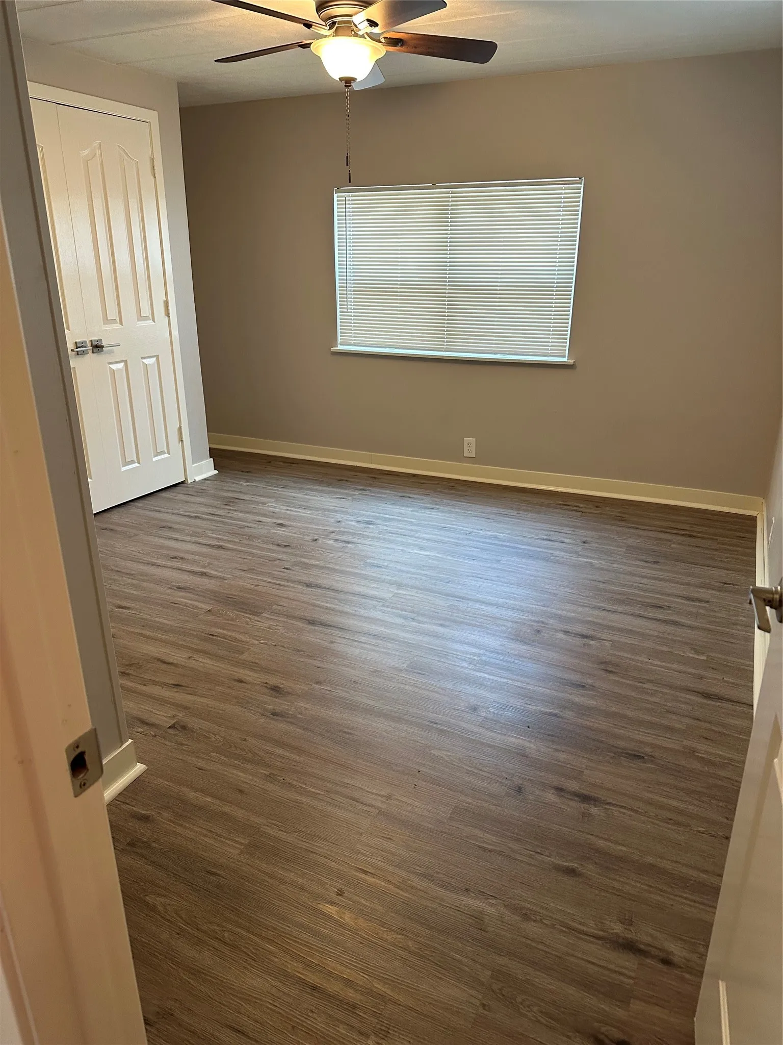 MBDRM featuring faux wood vinyl flooring, ceiling fan and closet.