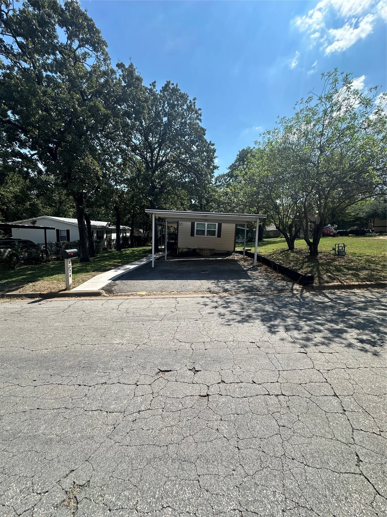 Street View featuring private covered parking with concrete sidewalk