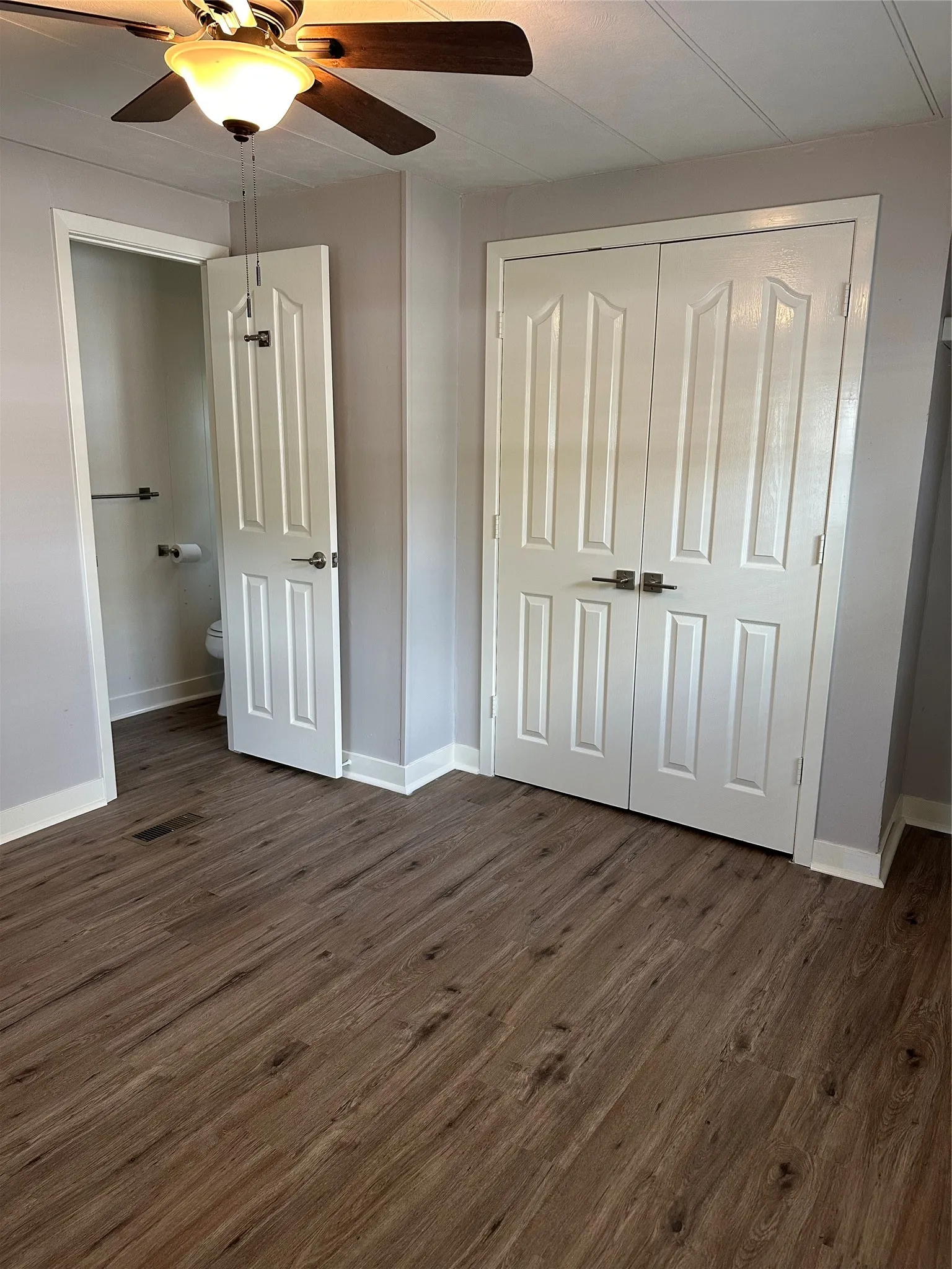 MBDRM with faux wood-look vinyl flooring, ceiling fan, a closet, and connected bathroom