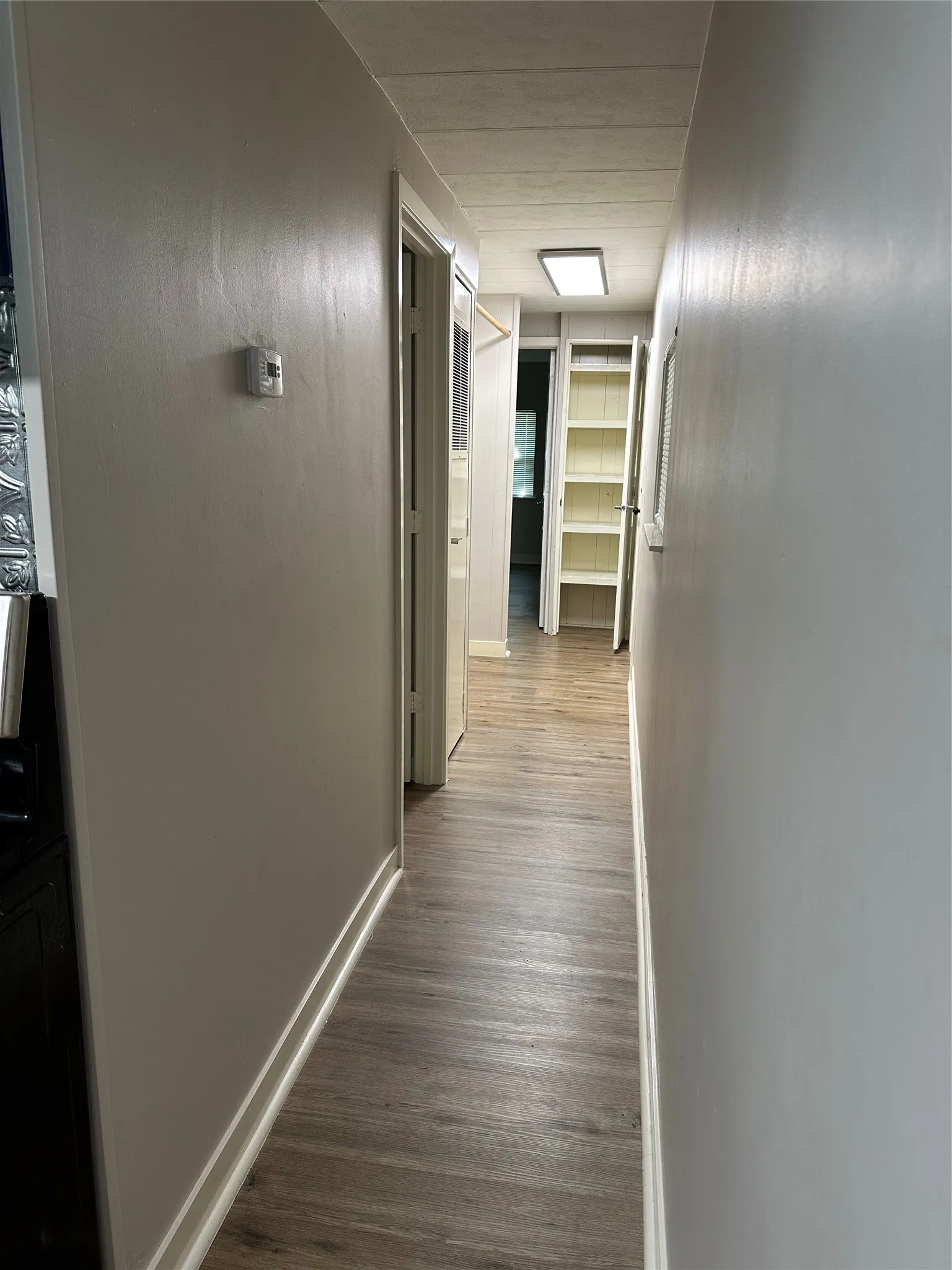 Corridor leading to split bedroom arrangement. Linen closet at end of hallway. Laundry Room on left of corridor.