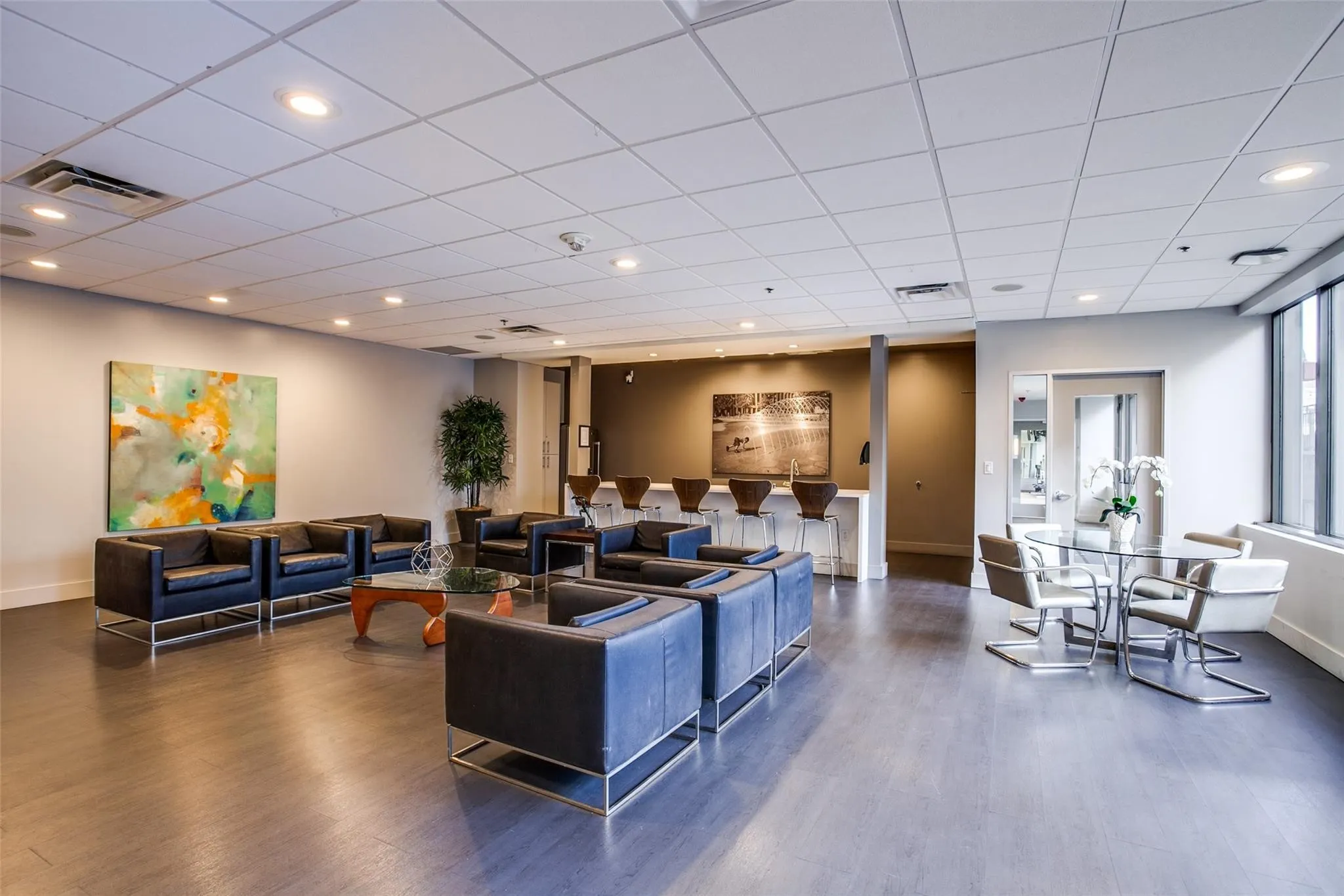 Spacious common area featuring wood-finish flooring, recessed lighting, and large windows