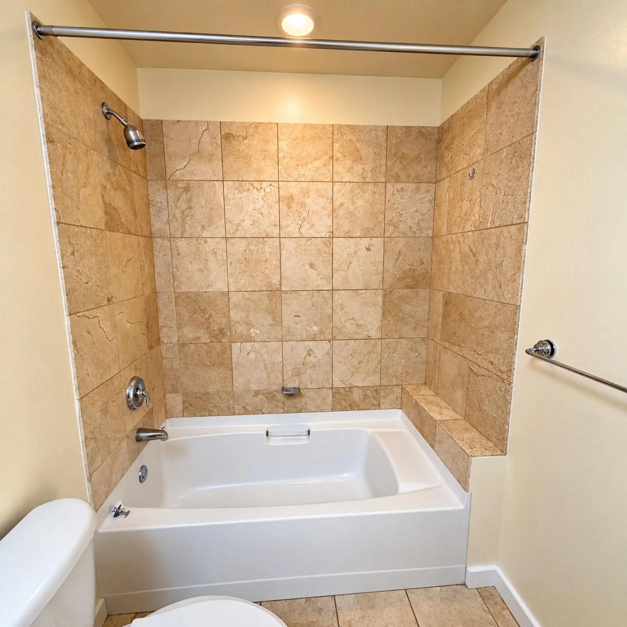 Bathtub with tiled surround, chrome fixtures, and recessed lighting