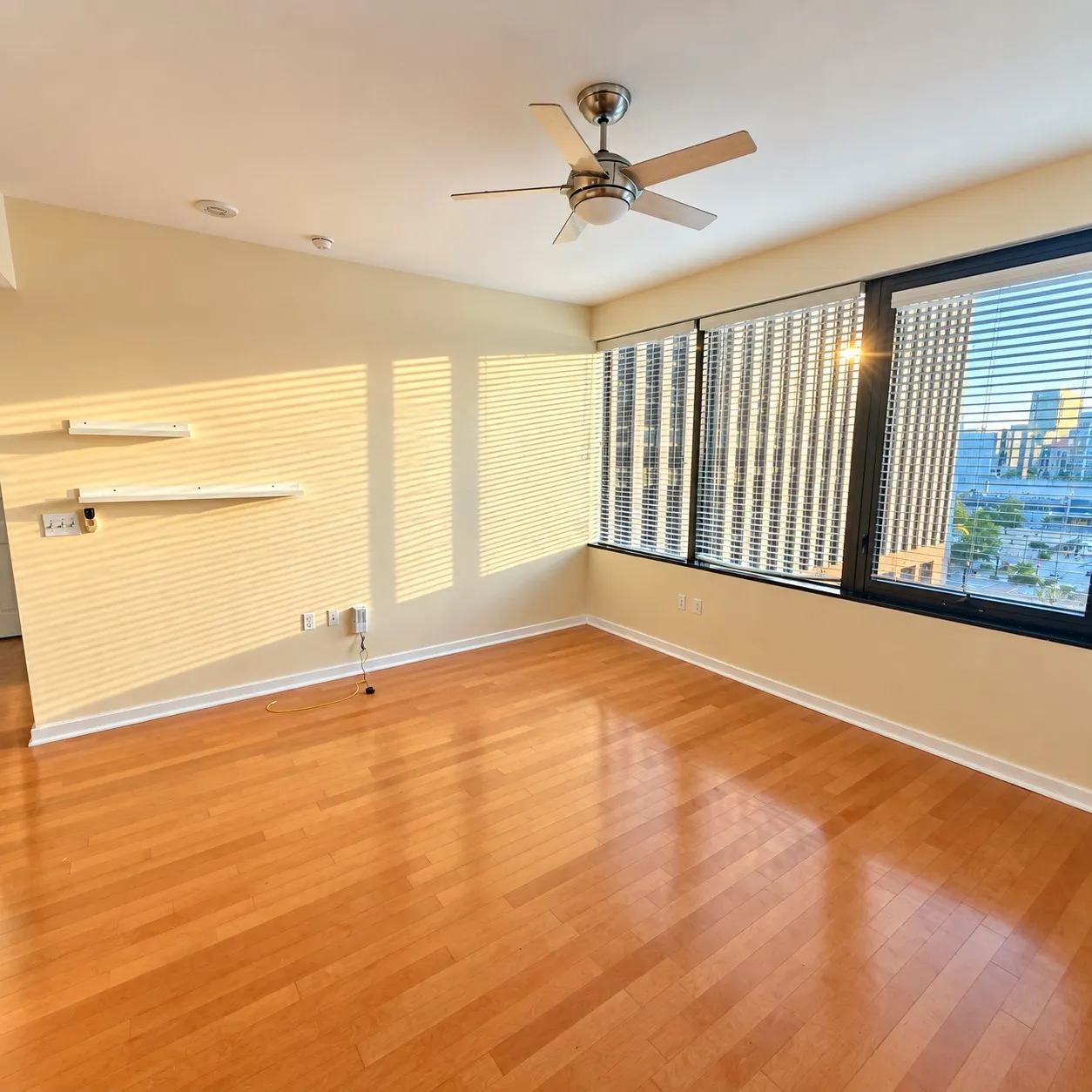 Wood-finish flooring with a ceiling fan, recessed lighting, and expansive windows featuring horizontal blinds