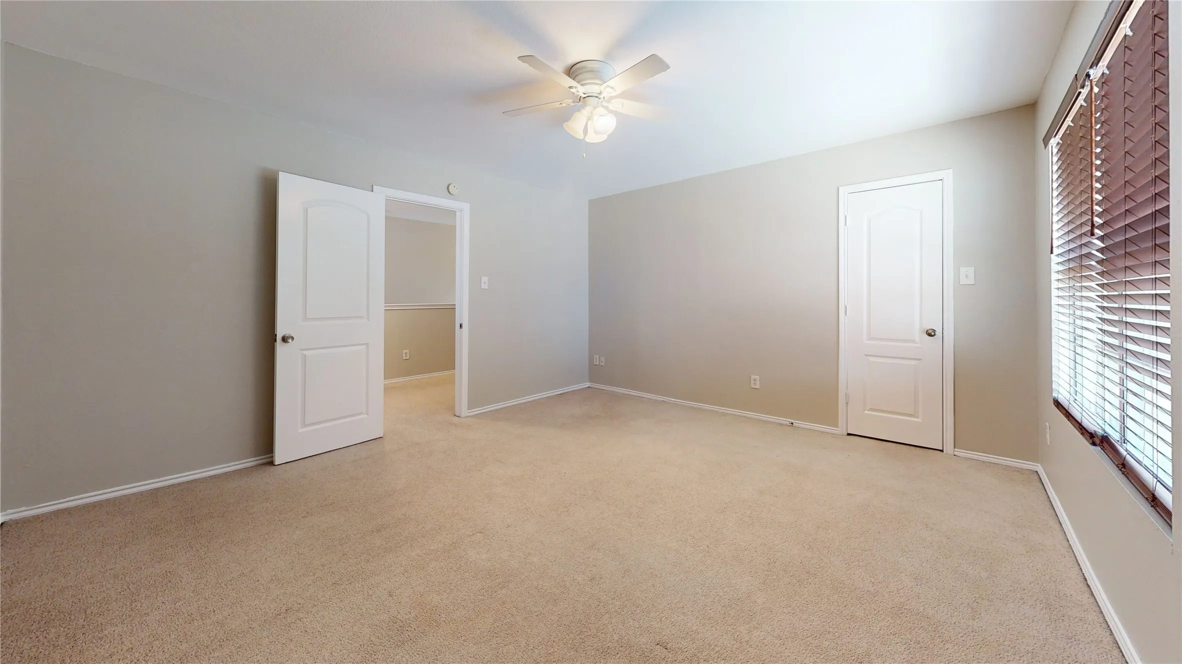 Carpeted flooring, ceiling fan, white paneled doors, neutral wall color, and window with blinds