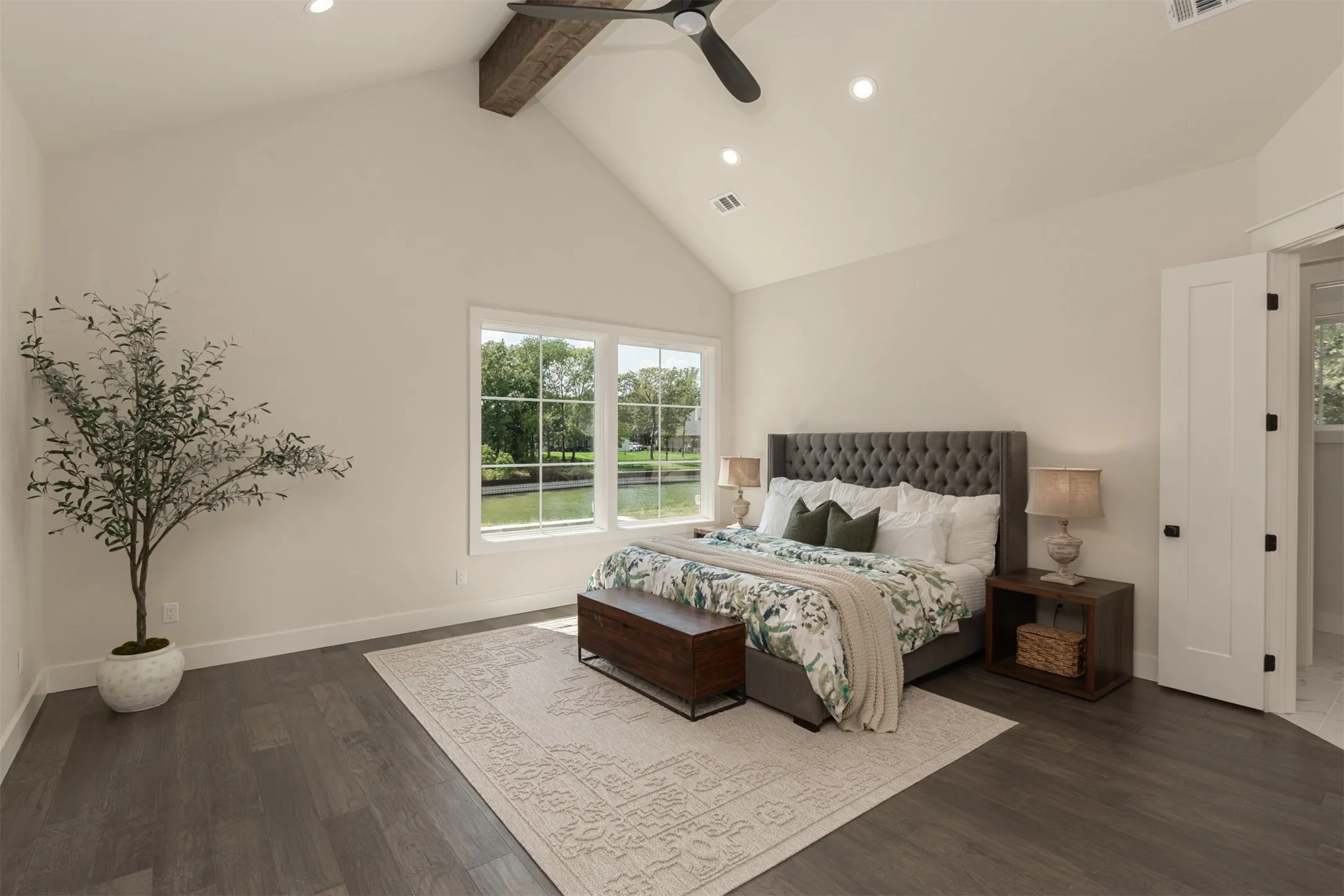 Vaulted ceiling with exposed wood beam, recessed lighting, ceiling fan, dark wood-finish flooring, and white trim