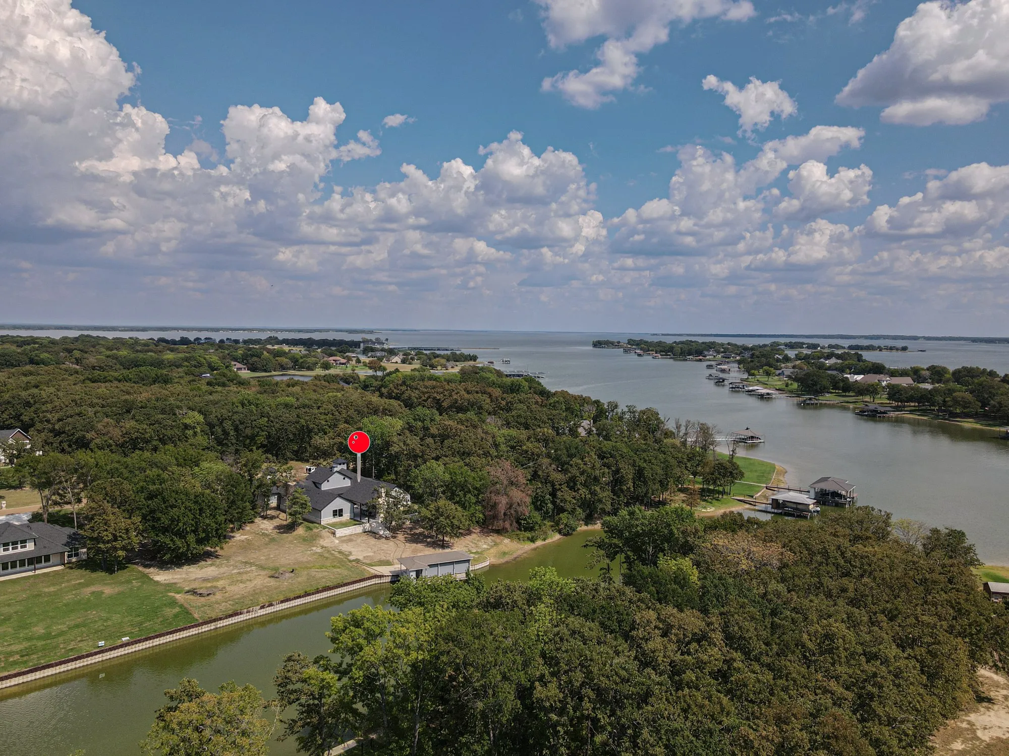 Waterfront property featuring a private boat dock, mature tree coverage, and direct canal access