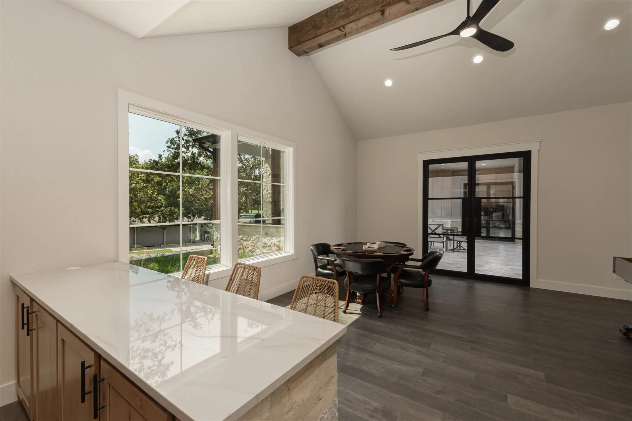 Vaulted ceiling with an exposed wood beam, recessed lighting, and a contemporary ceiling fan