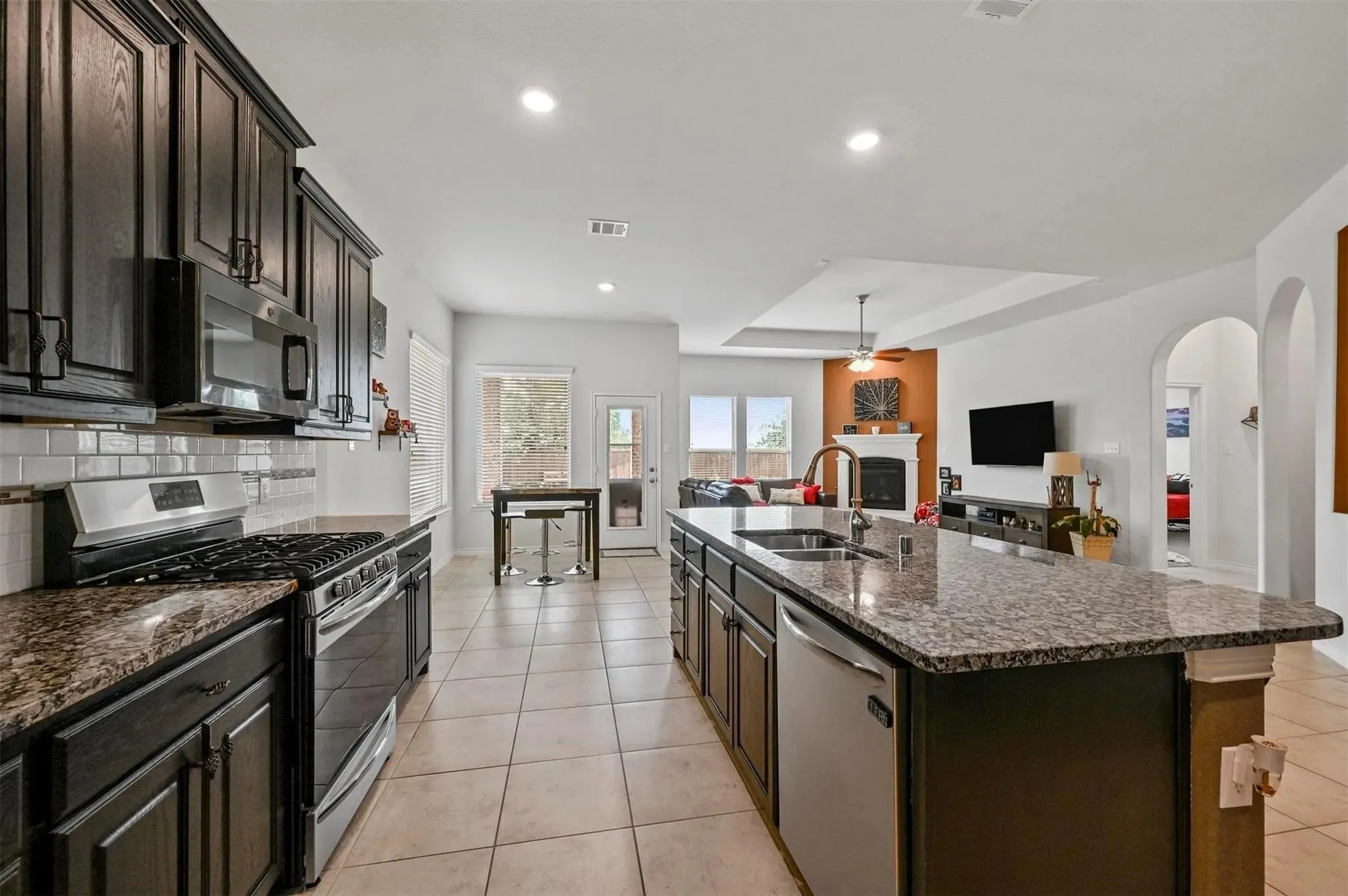 Kitchen features dark wood cabinetry, granite countertops, and stainless steel appliances