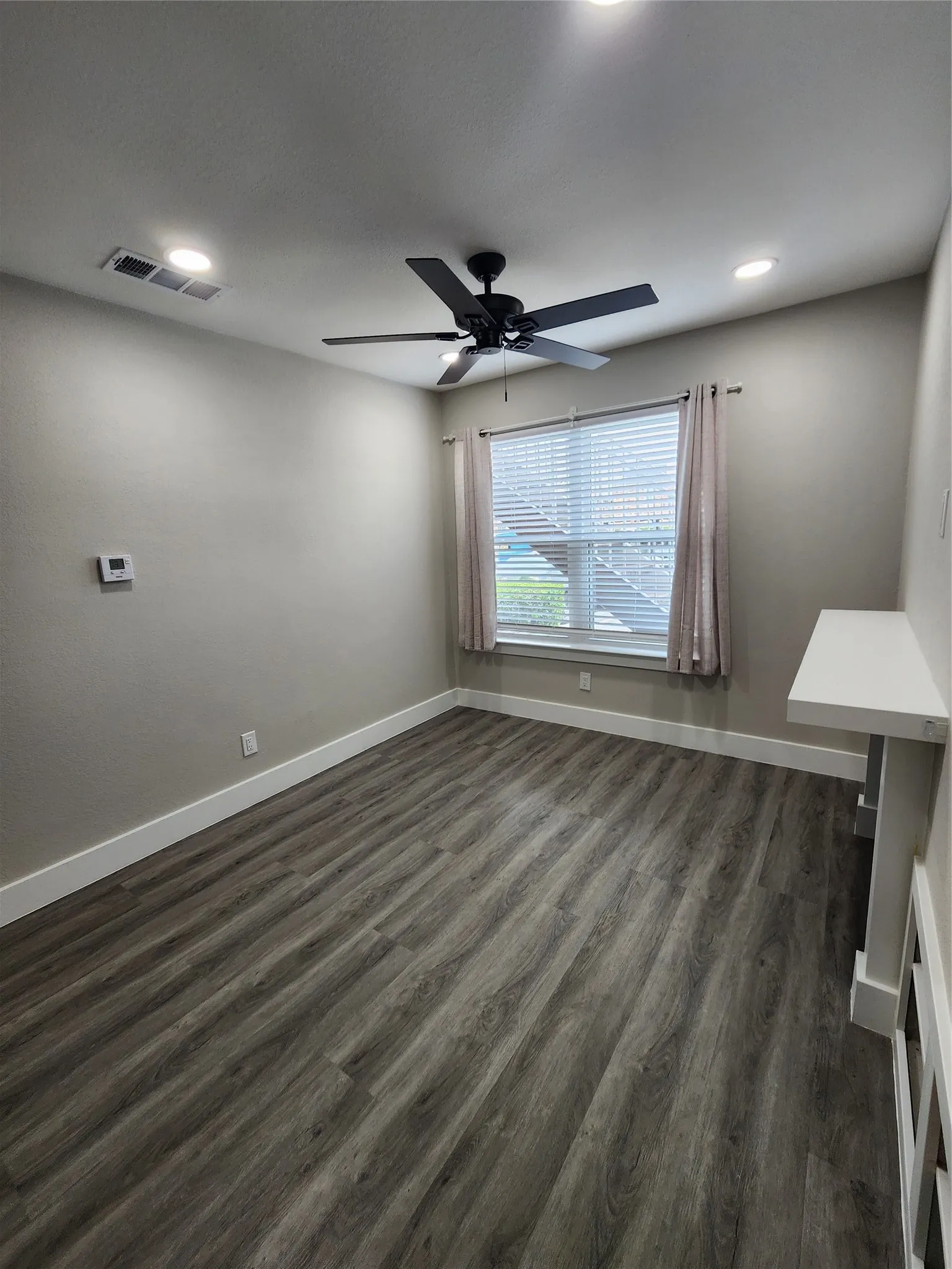 Wood-finish flooring, recessed lighting, ceiling fan, and a built-in shelf