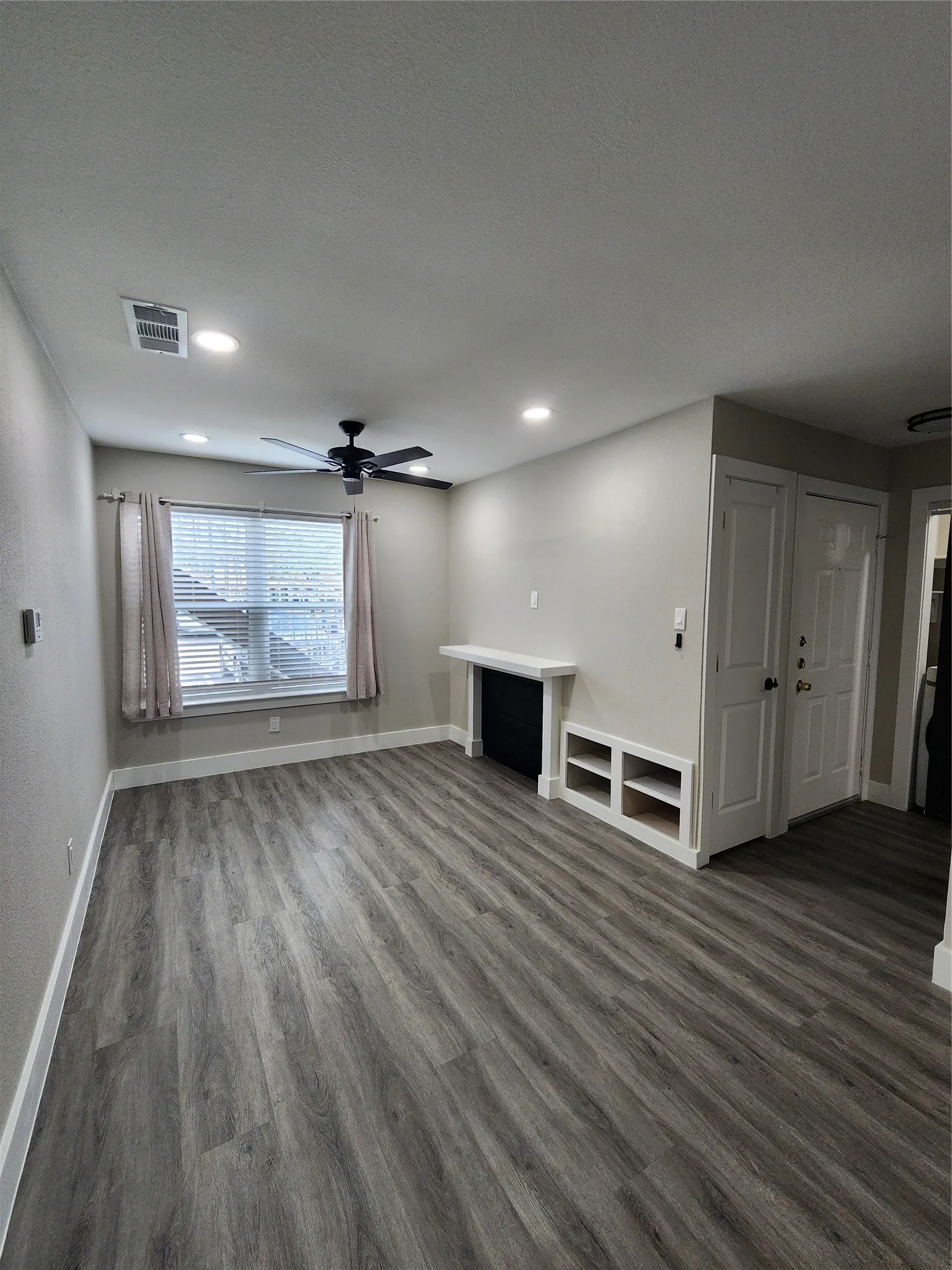 Recessed lighting, wood-finish flooring, ceiling fan, window with blinds, and built-in shelving