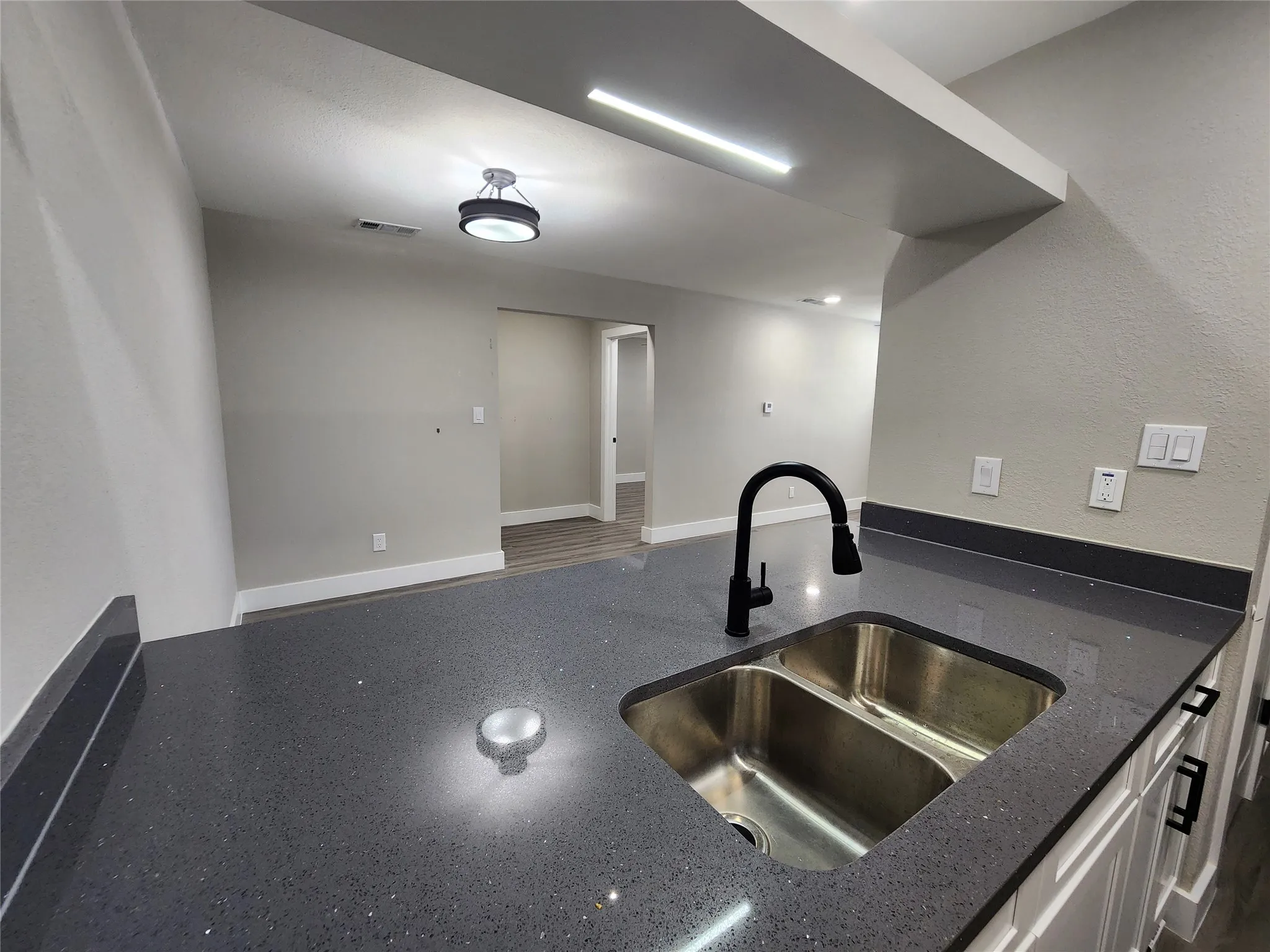 Dual basin stainless steel sink with a matte black gooseneck faucet