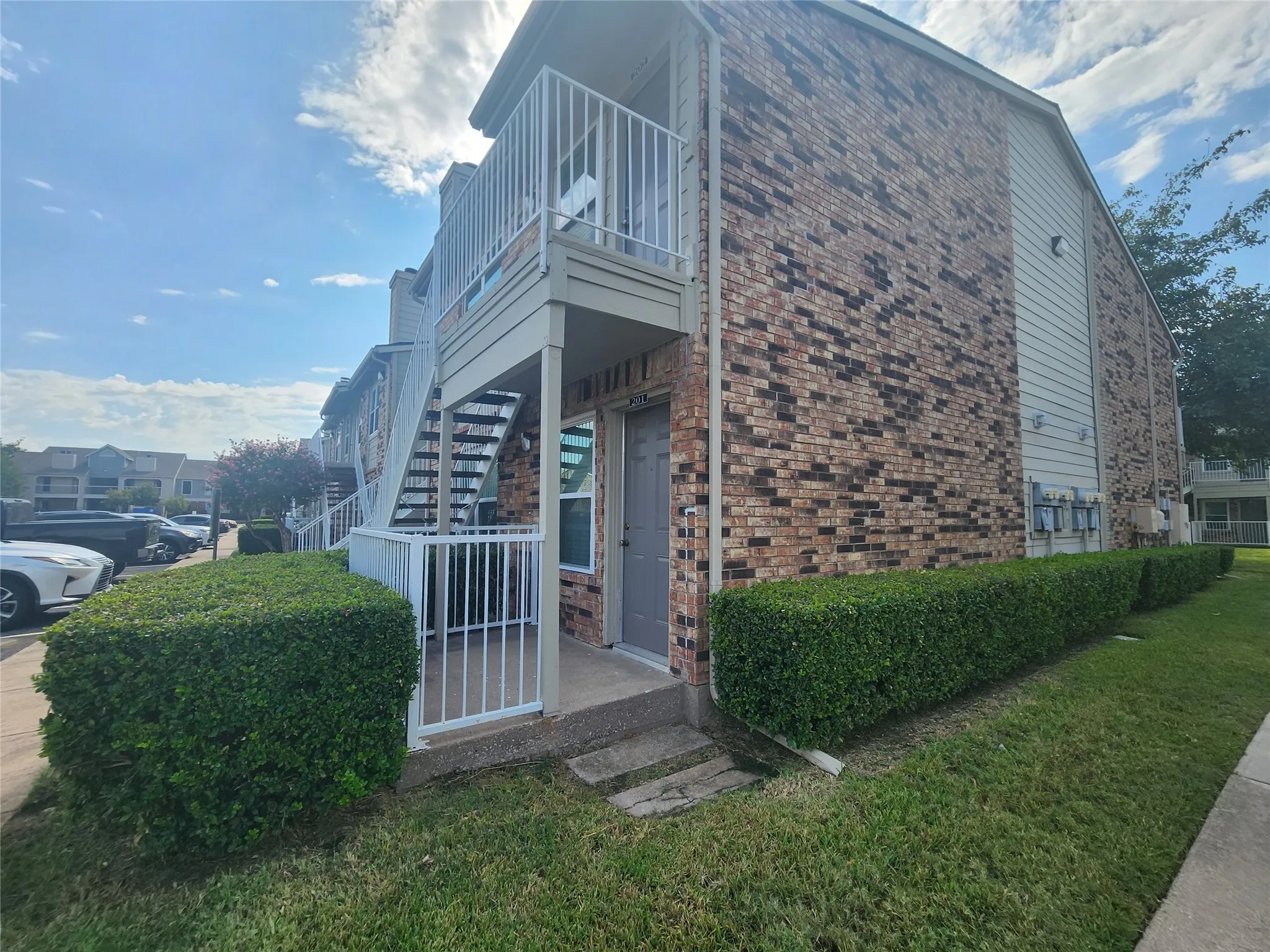 Brick exterior with siding accents, ground-level entry, and a private fenced patio