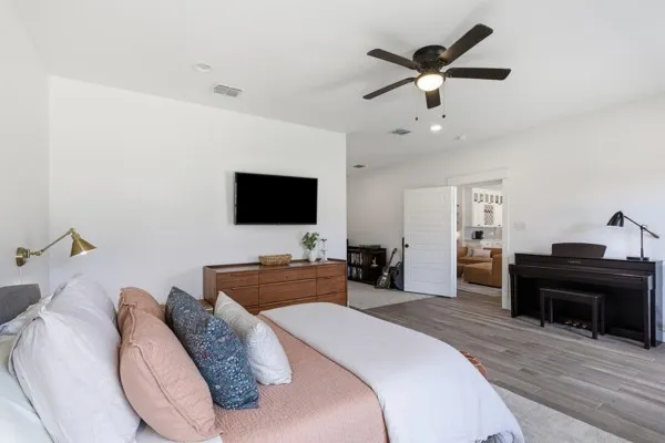 High ceilings, wood-finish flooring, recessed lighting, ceiling fan, and a wall-mounted brass fixture