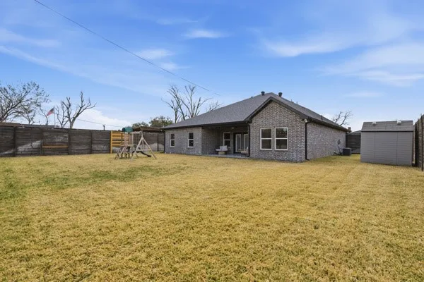 Brick exterior, fenced yard, covered patio, rear windows, storage shed