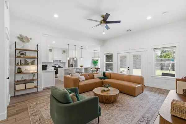 Open-concept living area with wood-finish flooring, recessed lighting, and a ceiling fan