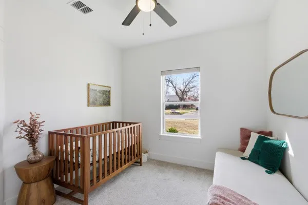 Carpeted room with a single window, ceiling fan, and white walls