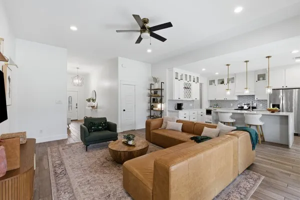 Open-concept living space featuring wood-finish flooring, recessed lighting, and a ceiling fan