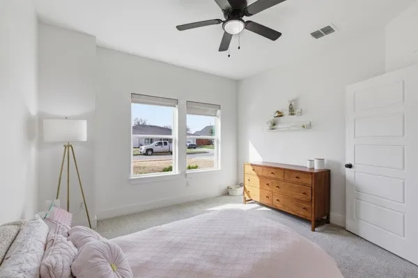 Neutral wall paint, plush carpet, and a ceiling fan with integrated lighting