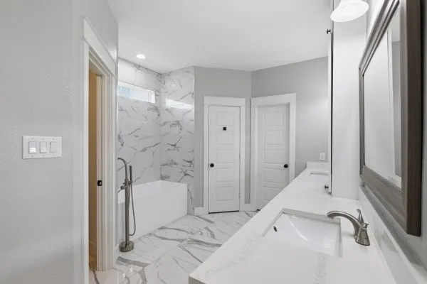 Dual sink vanity with white countertop, chrome fixtures, and framed mirror