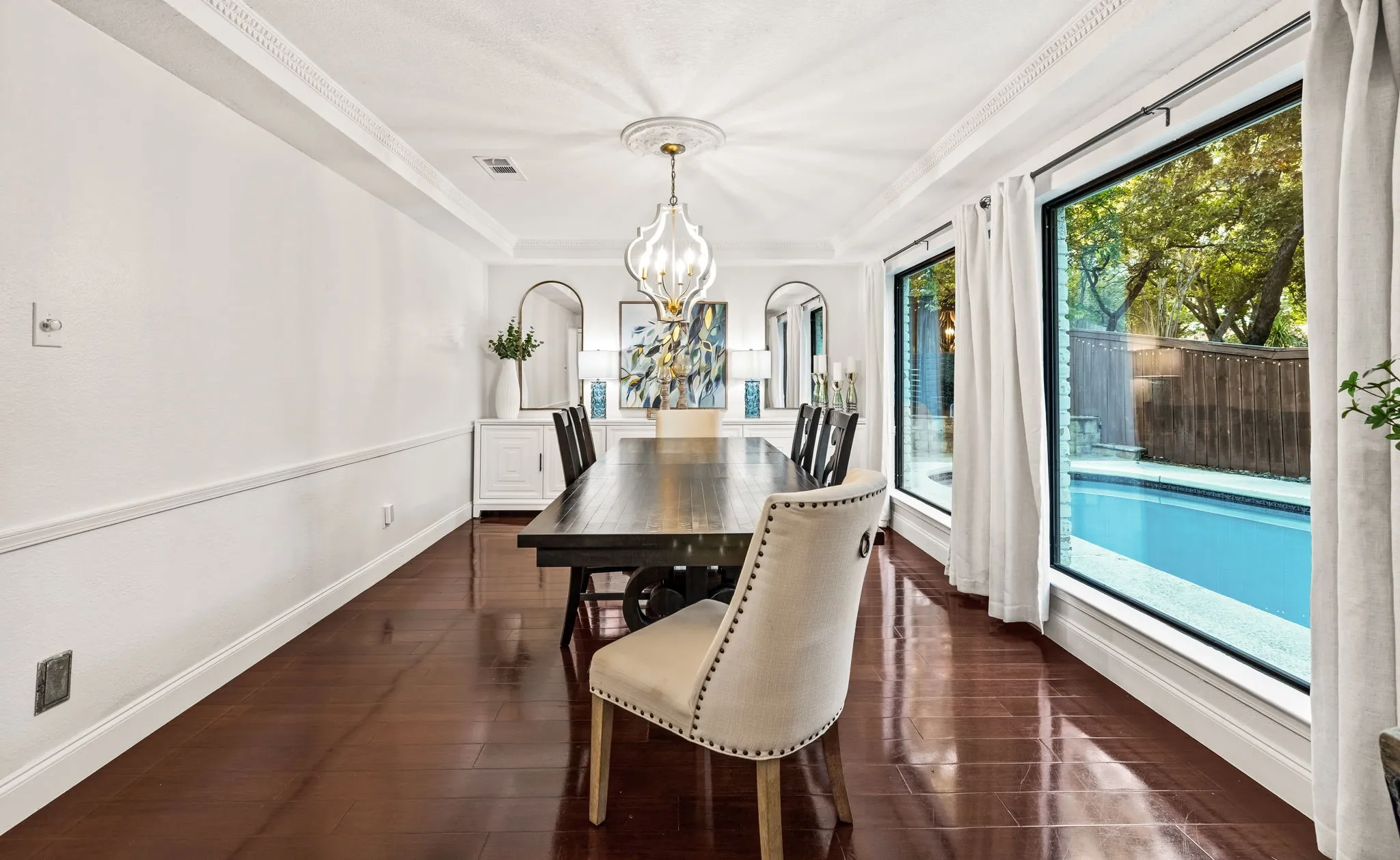 Hardwood-finish flooring, full-height windows, a built-in pool, and crown molding