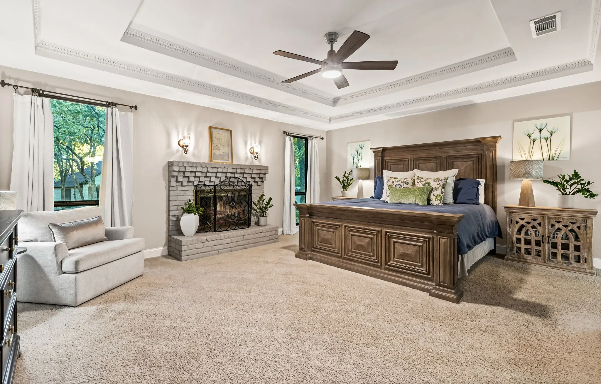 Tray ceiling with decorative trim, ceiling fan, and carpeted flooring