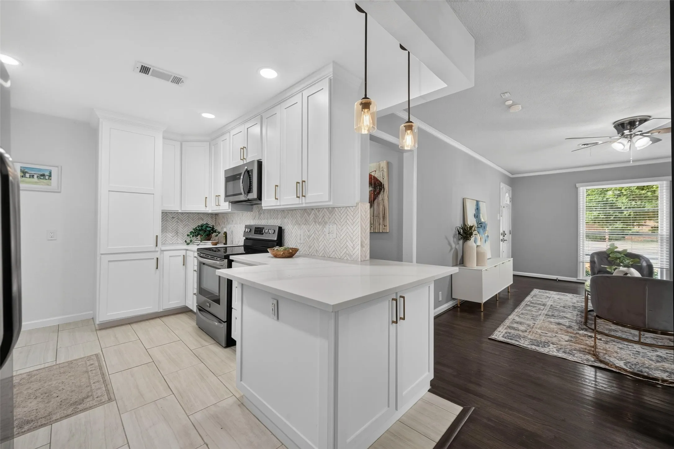 White shaker cabinetry, stainless steel appliances, herringbone tile backsplash, white countertop island, and dark wood-finish flooring