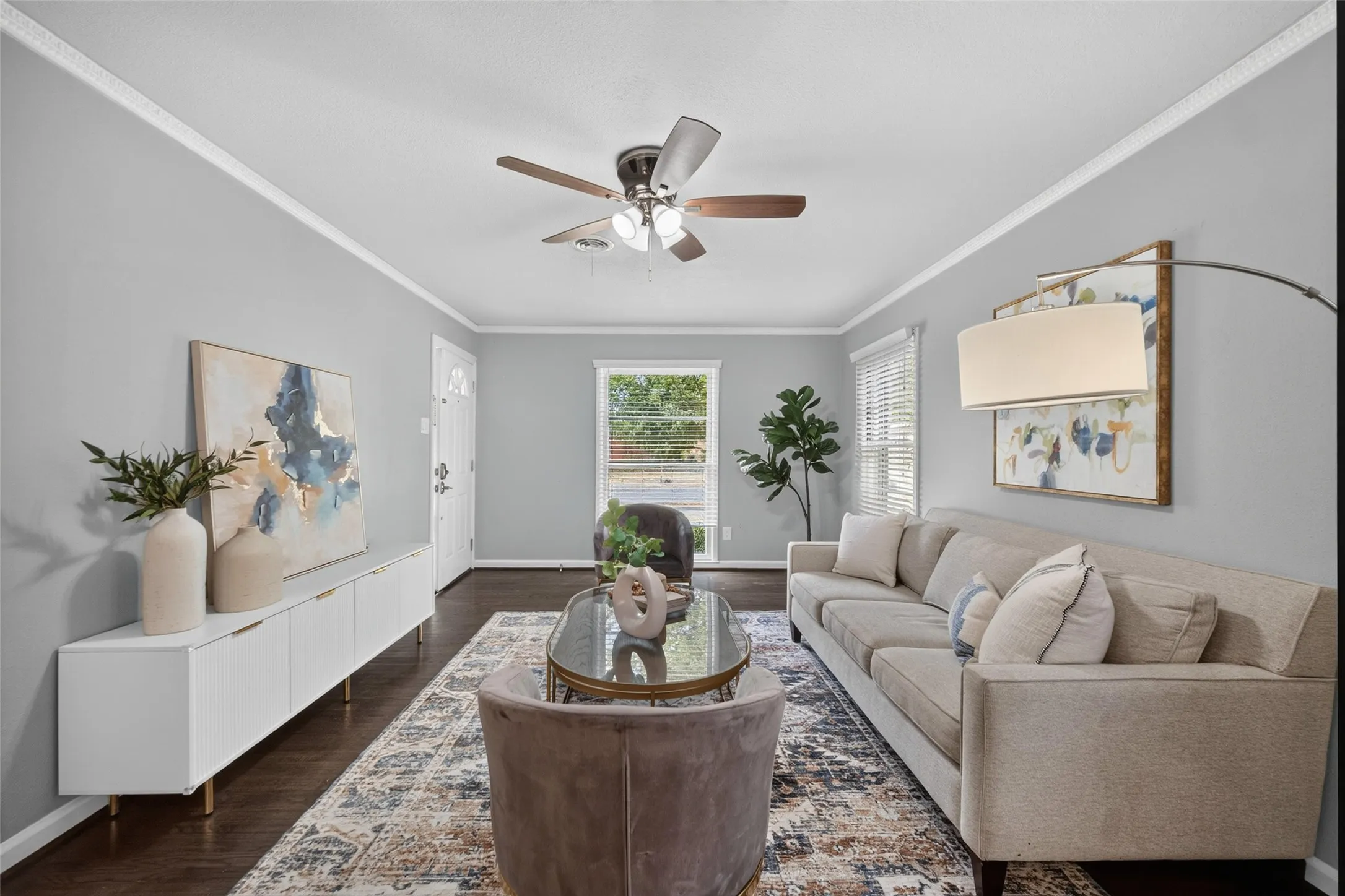 Hardwood-style flooring, a ceiling fan, and crown molding
